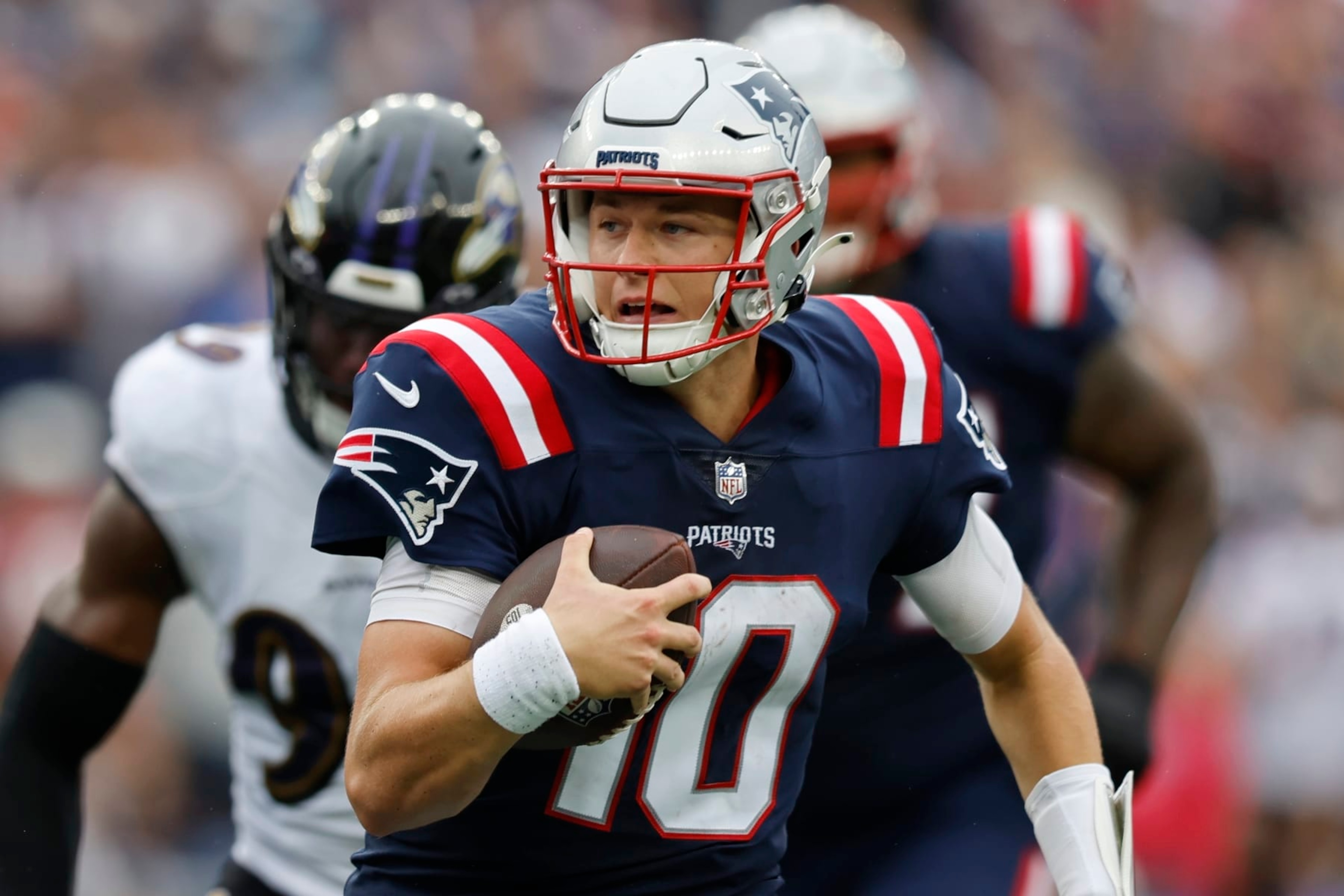New England Patriots quarterback Mac Jones (10) carries he ball during the second half of an NFL football game against the Baltimore Ravens, Sunday, Sept. 25, 2022, in Foxborough, Mass. (AP Photo/Michael Dwyer) New England Patriots quarterback Mac Jones (10) carries he ball during the second half of an NFL football game against the Baltimore Ravens, Sunday, Sept. 25, 2022, in Foxborough, Mass. (AP Photo/Michael Dwyer)