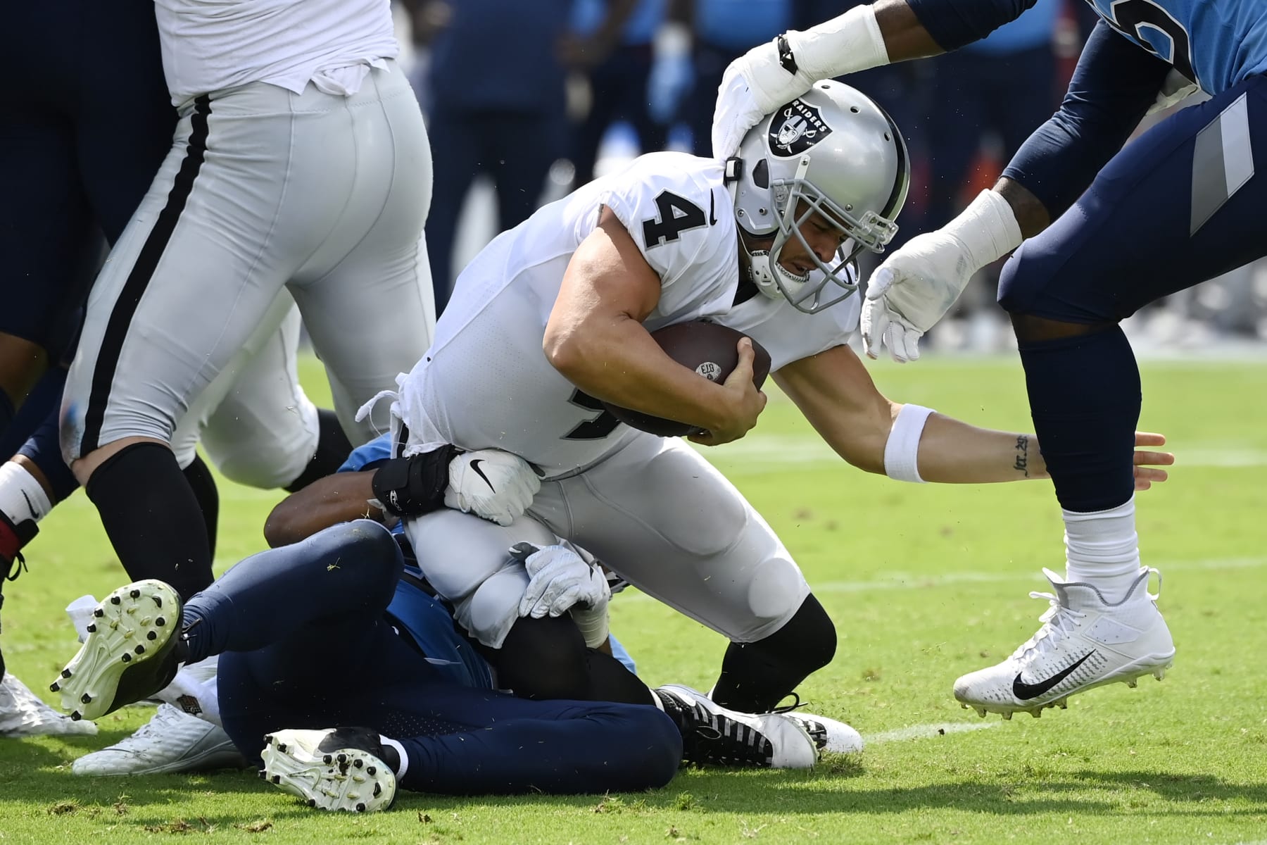 Las Vegas Raiders quarterback Derek Carr (4) is sacked by Tennessee Titans linebacker Rashad Weaver, bottom left, during the first half of an NFL football game Sunday, Sept. 25, 2022, in Nashville. (AP Photo/Mark Zaleski)