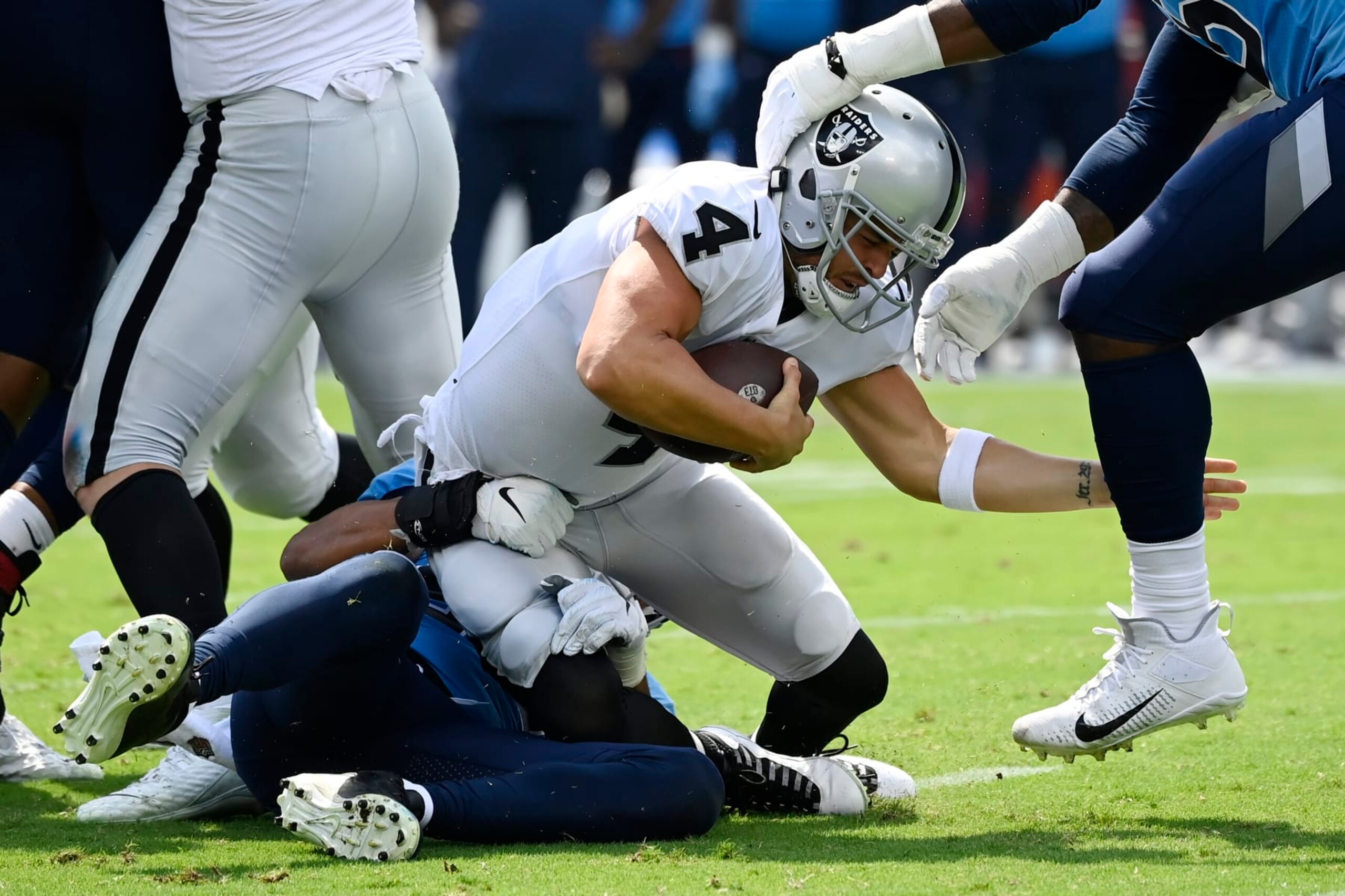Las Vegas Raiders quarterback Derek Carr (4) is sacked by Tennessee Titans linebacker Rashad Weaver, bottom left, during the first half of an NFL football game Sunday, Sept. 25, 2022, in Nashville. (AP Photo/Mark Zaleski)