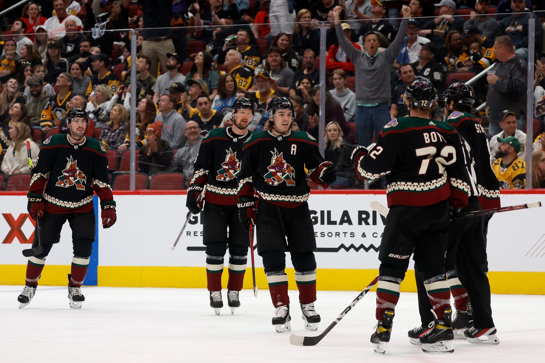 GLENDALE, ARIZONA - MARCH 19: Clayton Keller #9 of the Arizona Coyotes celebrates with Travis Boyd #72 and Nick Schmaltz #8 after scoring a goal against the Pittsburgh Penguins during the second period of the NHL game at Gila River Arena on March 19, 2022 in Glendale, Arizona. (Photo by Christian Petersen/Getty Images)