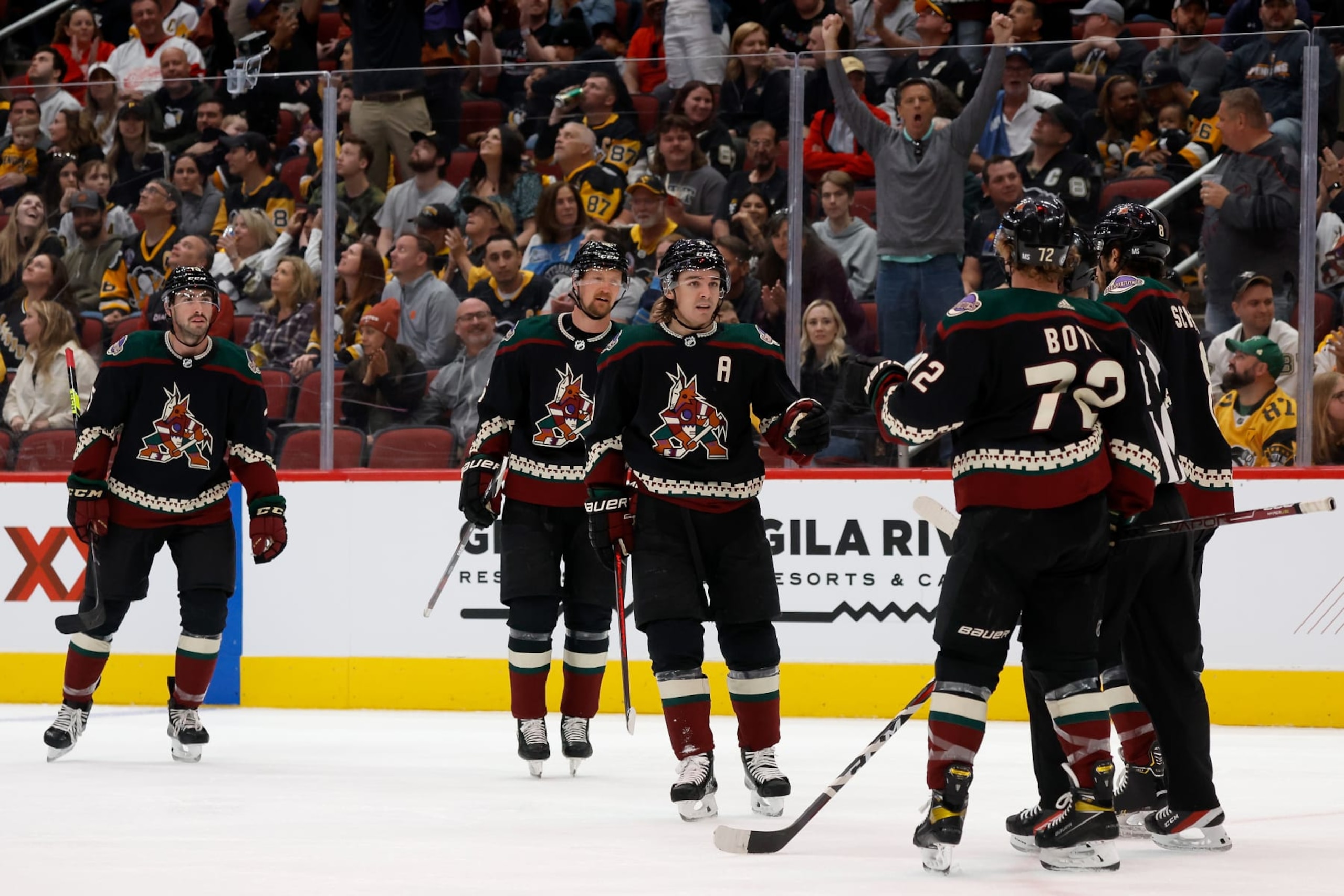 GLENDALE, ARIZONA - MARCH 19: Clayton Keller #9 of the Arizona Coyotes celebrates with Travis Boyd #72 and Nick Schmaltz #8 after scoring a goal against the Pittsburgh Penguins during the second period of the NHL game at Gila River Arena on March 19, 2022 in Glendale, Arizona. (Photo by Christian Petersen/Getty Images)