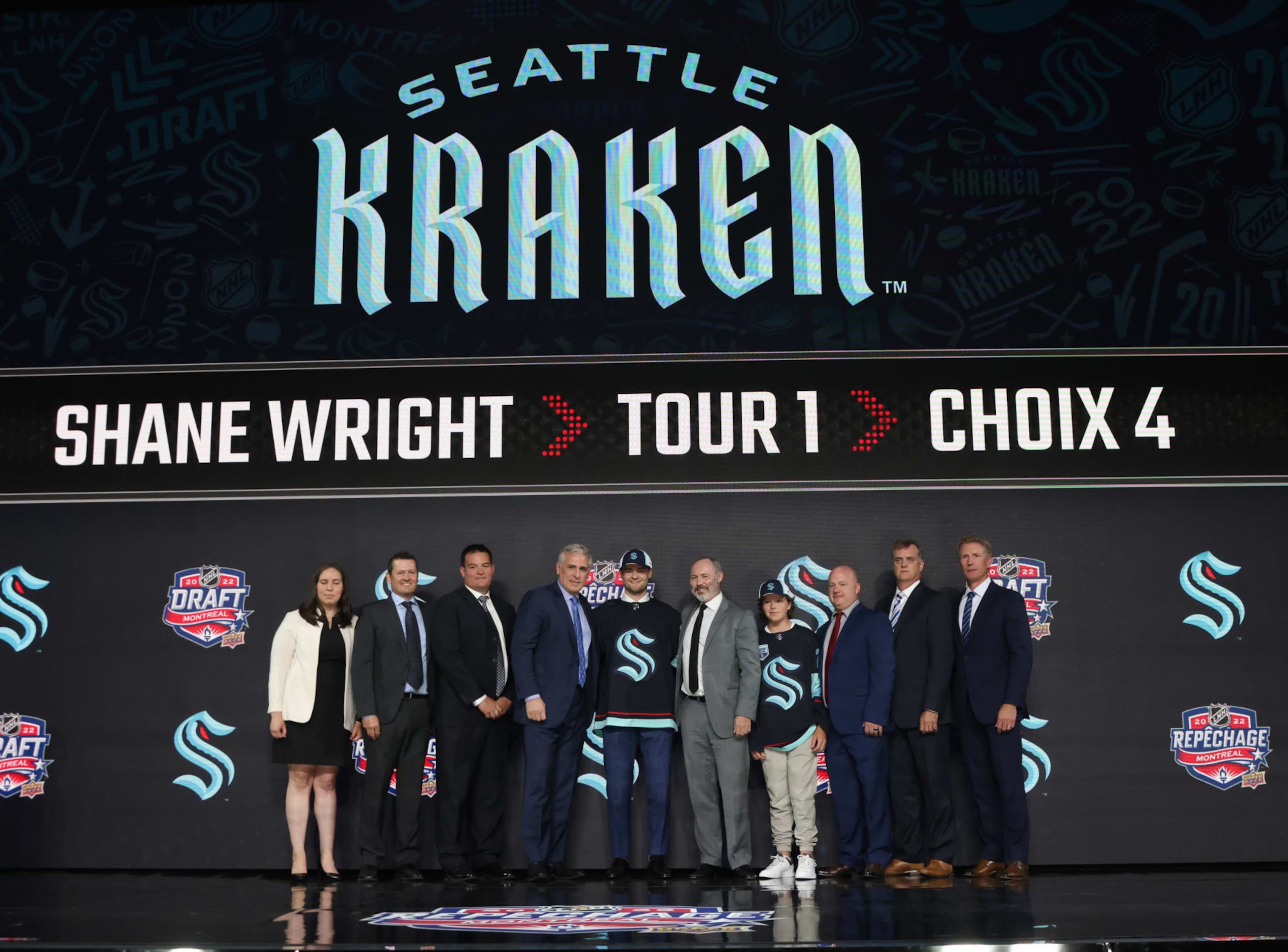 MONTREAL, QUEBEC - JULY 07: Shane Wright poses for a group photo with team personnel onstage after being selected fourth overall by the Seattle Kraken during the first round of the 2022 Upper Deck NHL Draft at Bell Centre on July 07, 2022 in Montreal, Quebec. (Photo by Dave Sandford/NHLI via Getty Images)