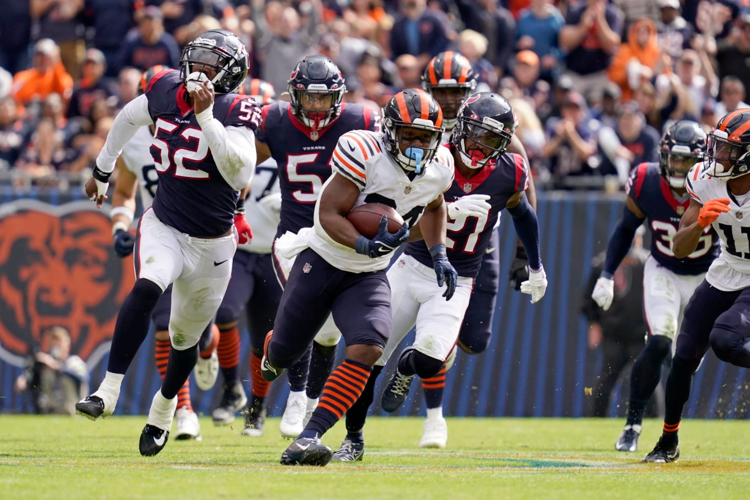 Chicago Bears running back Khalil Herbert, center, runs for a gain of 52 yards as Houston Texans defenders chase him during the second half of an NFL football game Sunday, Sept. 25, 2022, in Chicago. (AP Photo/Nam Y. Huh)