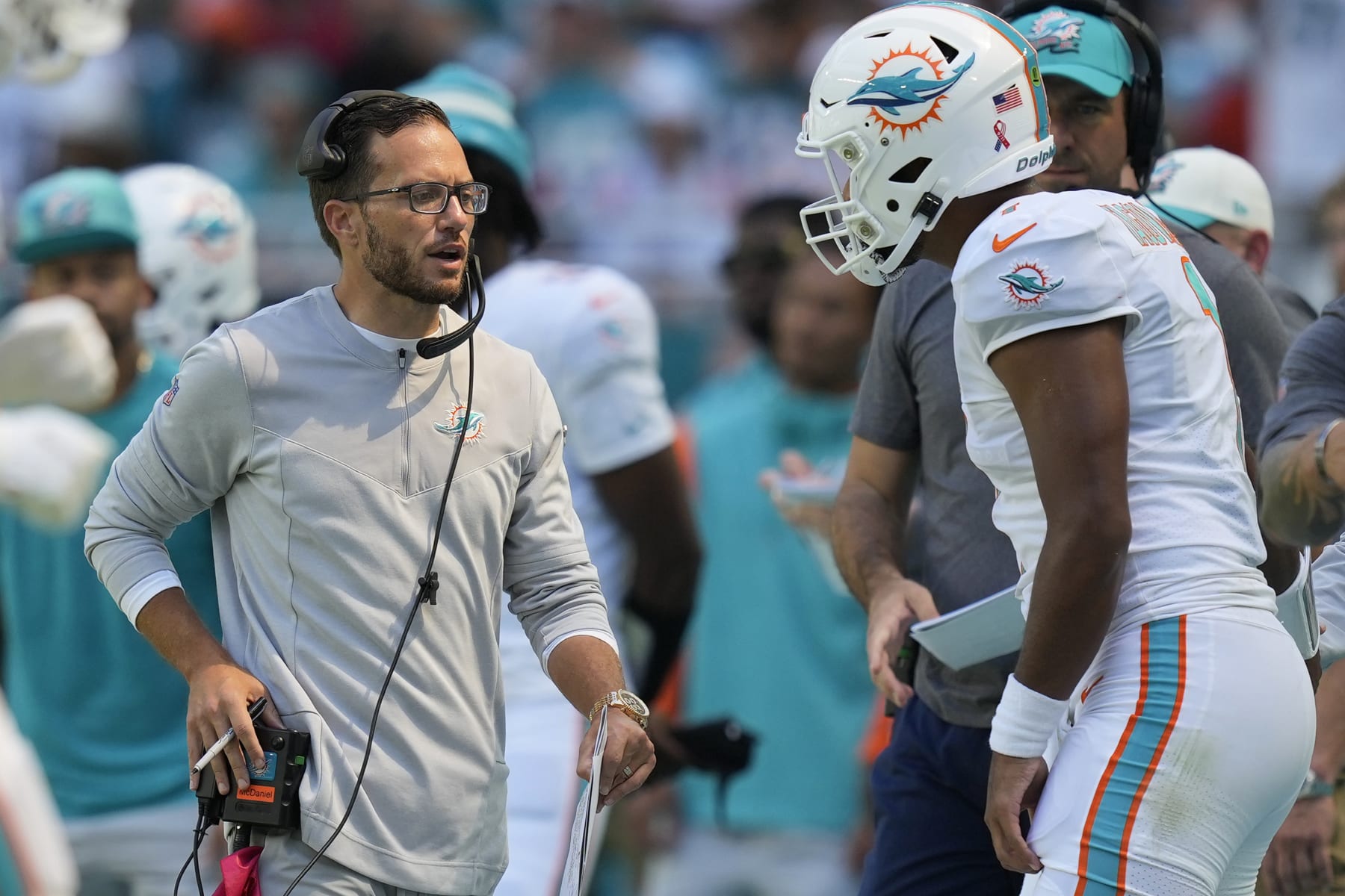 Miami Dolphins head coach Mike McDaniel talks to quarterback Tua Tagovailoa (1) during the second half of an NFL football game against the New England Patriots, Sunday, Sept. 11, 2022, in Miami Gardens, Fla. (AP Photo/Rebecca Blackwell)