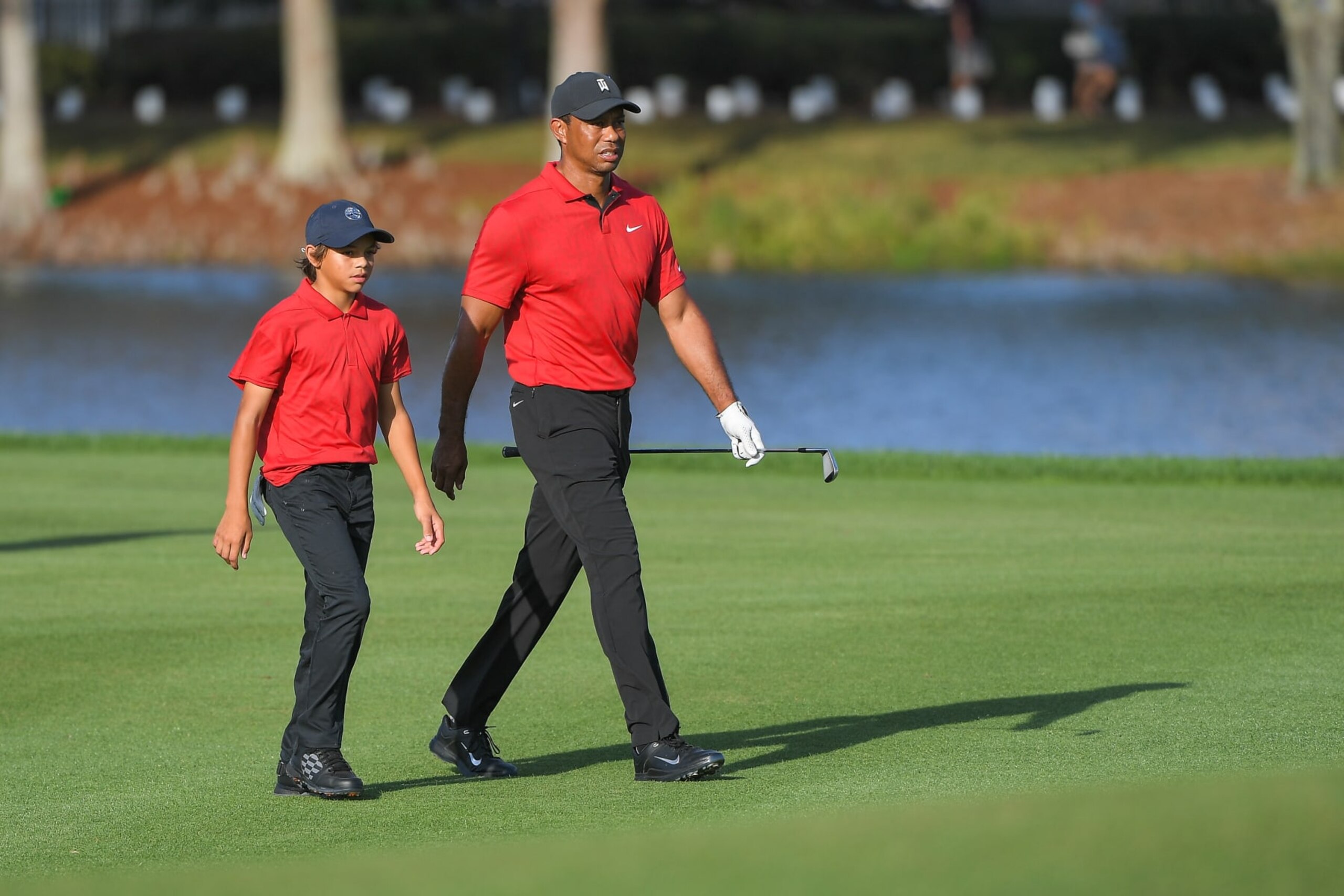 ORLANDO, FL - DECEMBER 19: Tiger Woods walks with his son, Charlie Woods, along the 18th fairway during the final round of the PGA TOUR Champions PNC Championship at Ritz-Carlton Golf Club on December 19, 2021 in Orlando, Florida. (Photo by Ben Jared/PGA TOUR)