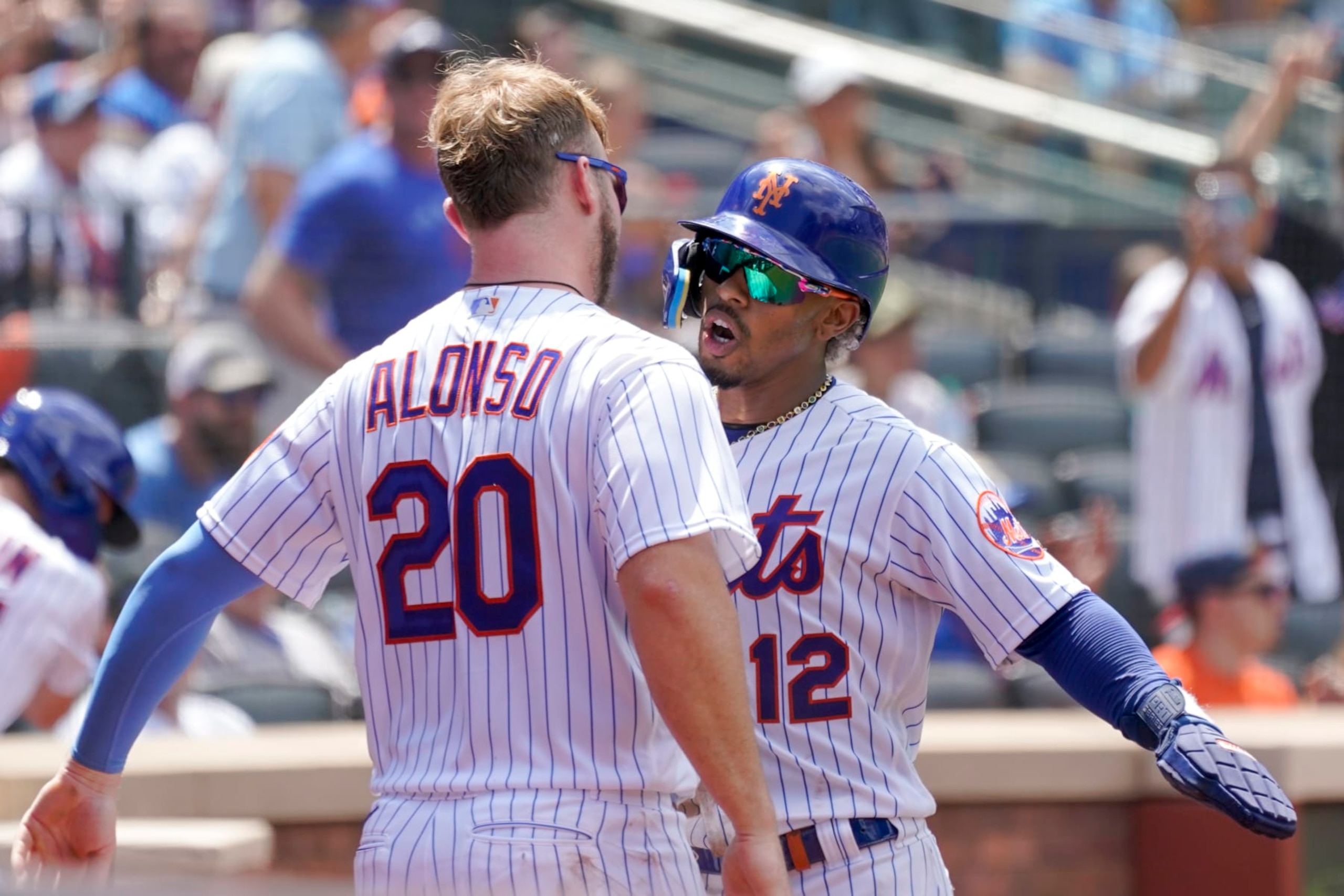 New York Mets' Francisco Lindor (12) and Pete Alonso celebrate after Lindor scored off an an RBI-double by Jeff McNeil in the third inning of game one of a double header baseball game against the Atlanta Braves, Saturday, Aug. 6, 2022, in New York. (AP Photo/Mary Altaffer)