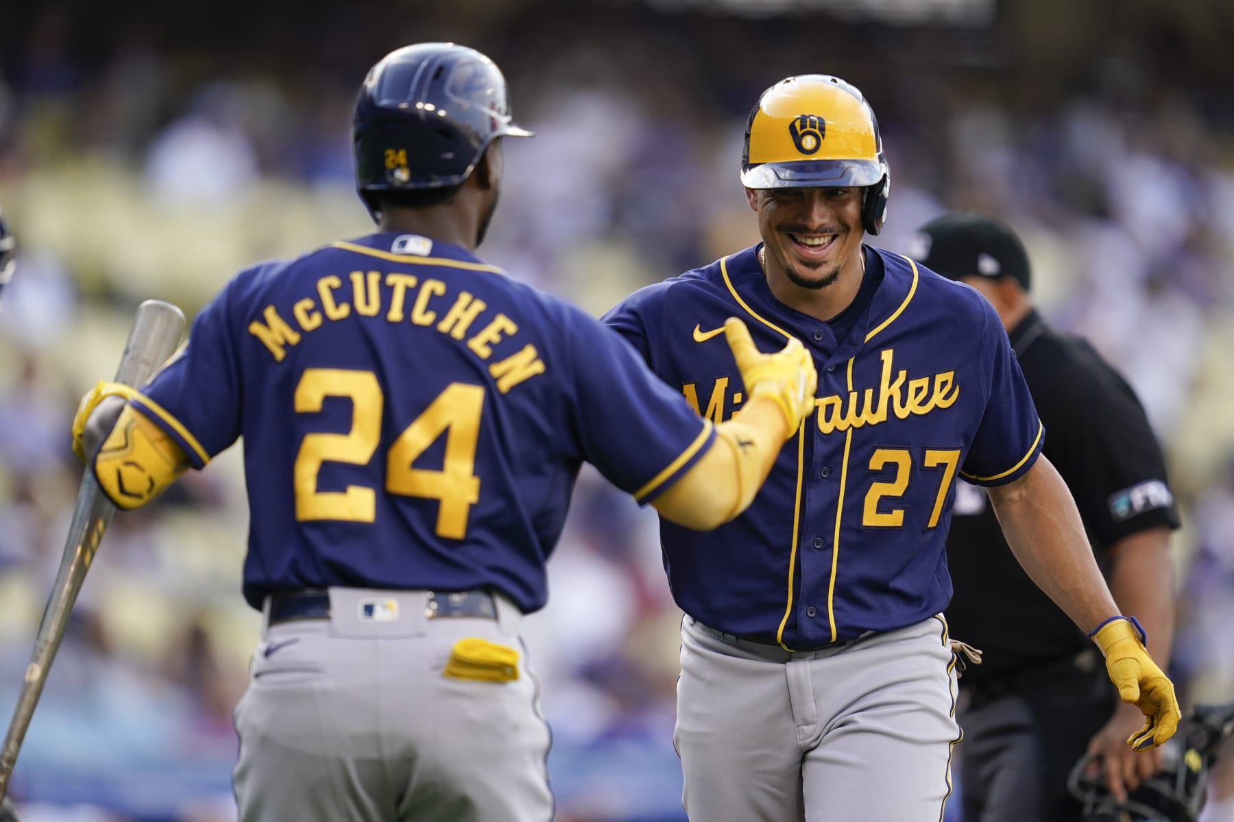 Milwaukee Brewers' Willy Adames (27) celebrates with Andrew McCutchen (24) after hitting a home run during the first inning of a baseball game against the Los Angeles Dodgers in Los Angeles, Wednesday, Aug. 24, 2022. (AP Photo/Ashley Landis)