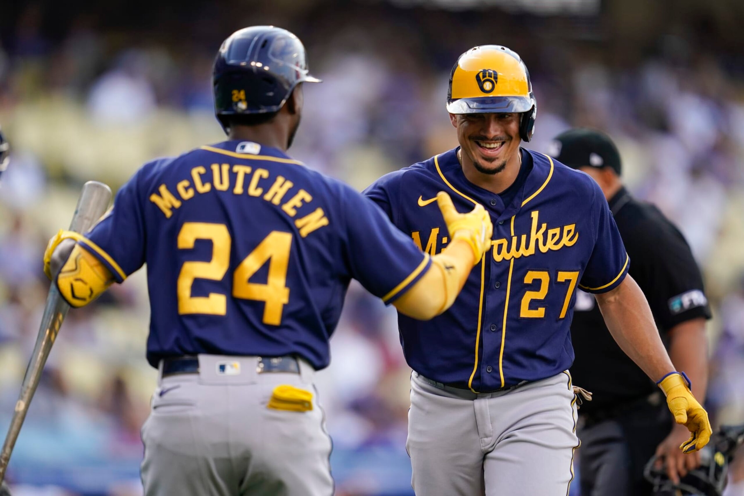 Milwaukee Brewers' Willy Adames (27) celebrates with Andrew McCutchen (24) after hitting a home run during the first inning of a baseball game against the Los Angeles Dodgers in Los Angeles, Wednesday, Aug. 24, 2022. (AP Photo/Ashley Landis)