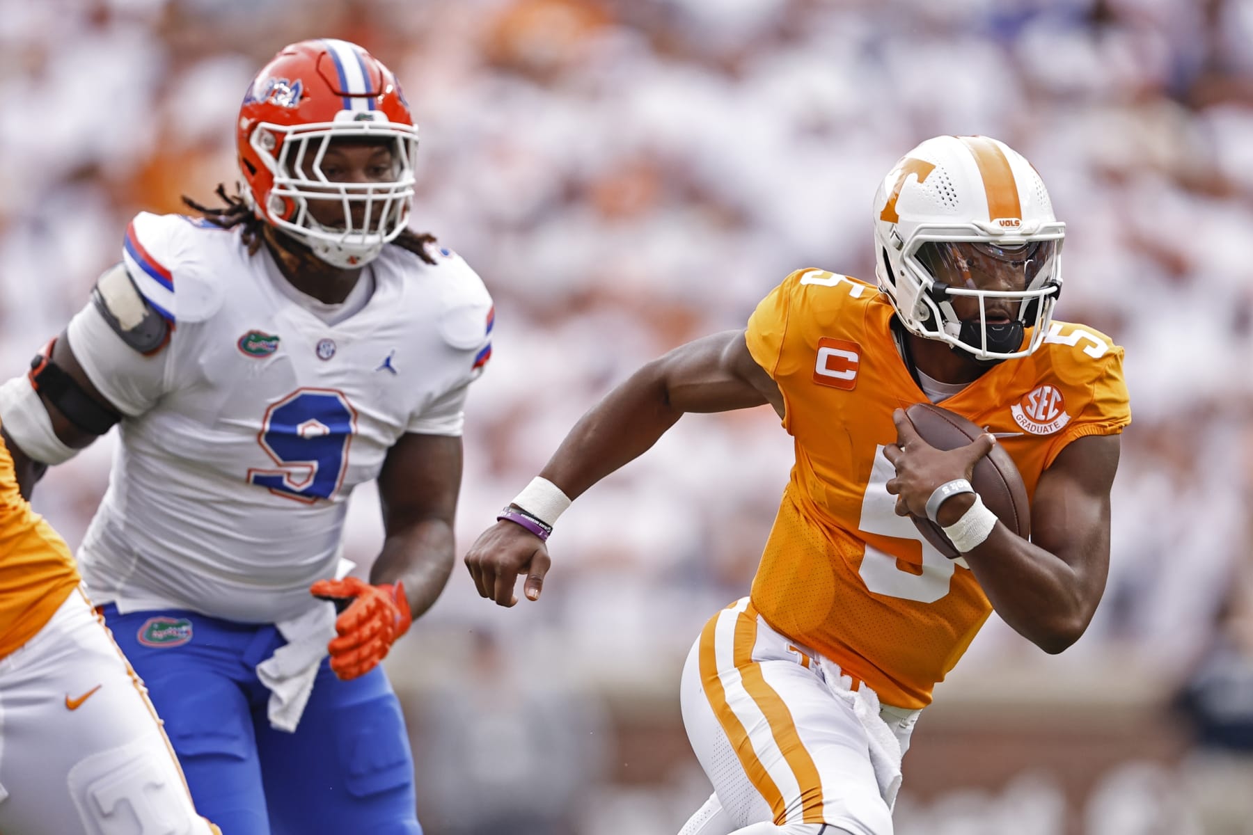Tennessee quarterback Hendon Hooker (5) runs for yardages as he's chased by Florida defensive lineman Gervon Dexter Sr. (9) during the first half of an NCAA college football game Saturday, Sept. 24, 2022, in Knoxville, Tenn. (AP Photo/Wade Payne)