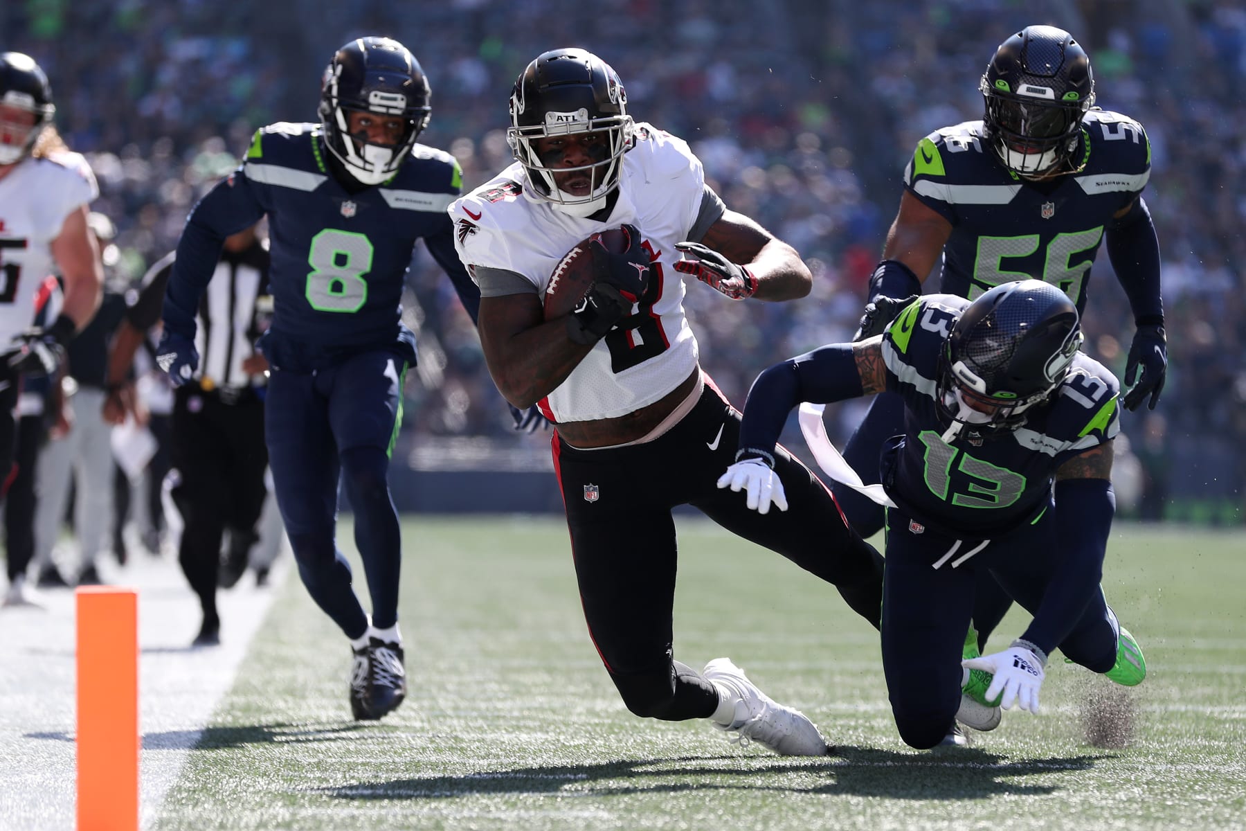 SEATTLE, WASHINGTON - SEPTEMBER 25: Josh Jones #13 of the Seattle Seahawks tackles Kyle Pitts #8 of the Atlanta Falcons during the first quarter at Lumen Field on September 25, 2022 in Seattle, Washington. (Photo by Steph Chambers/Getty Images)