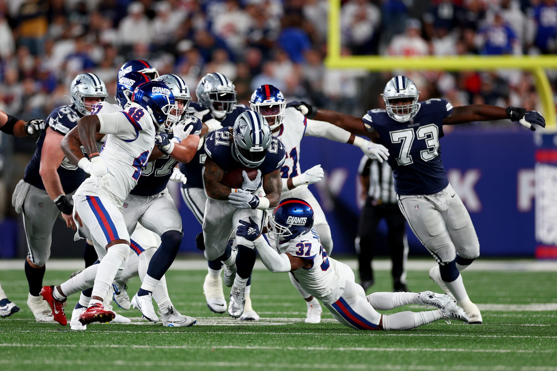 EAST RUTHERFORD, NEW JERSEY - SEPTEMBER 26: Ezekiel Elliott #21 of the Dallas Cowboys runs the ball against Darren Evans #37 of the New York Giants during the second quarter in the game at MetLife Stadium on September 26, 2022 in East Rutherford, New Jersey. (Photo by Elsa/Getty Images)