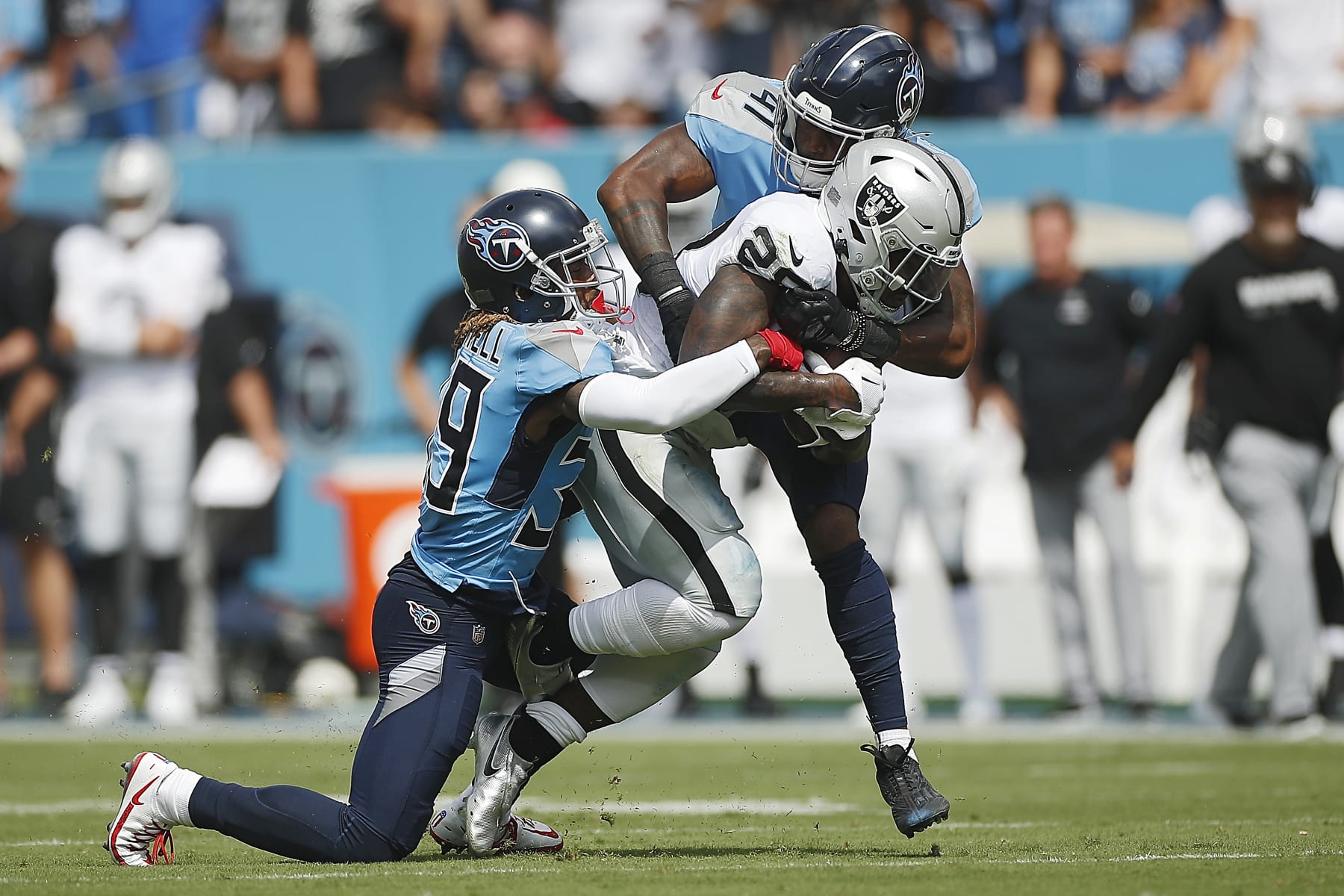 NASHVILLE, TENNESSEE - SEPTEMBER 25: Josh Jacobs #28 of the Las Vegas Raiders is tackled by Terrance Mitchell #39 and Zach Cunningham #41 of the Tennessee Titans during the second quarter at Nissan Stadium on September 25, 2022 in Nashville, Tennessee. (Photo by Silas Walker/Getty Images)