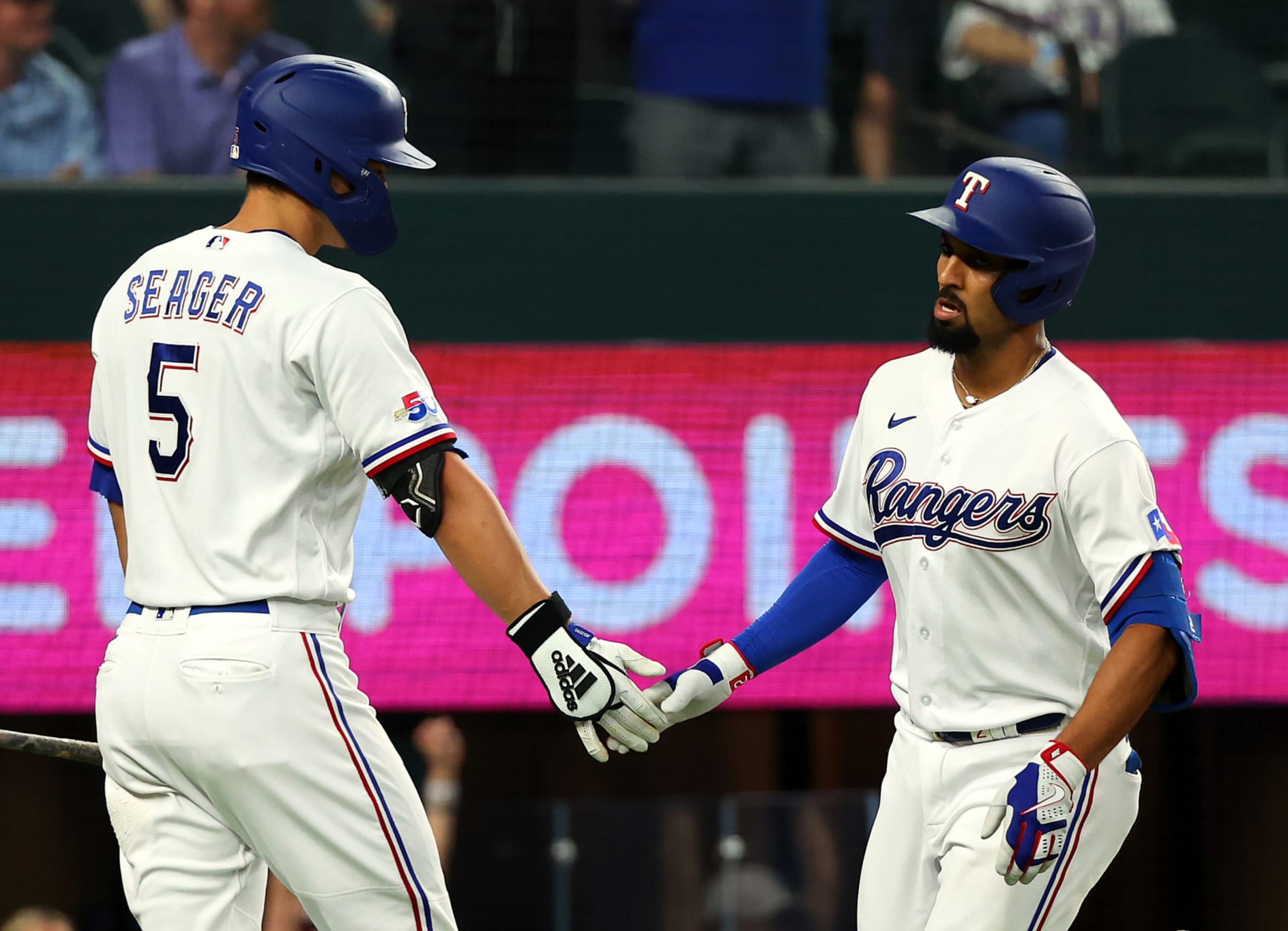 ARLINGTON, TEXAS - SEPTEMBER 24: Corey Seager #5 of the Texas Rangers greets Marcus Semien #2 of the Texas Rangers after a solo home run in the third inning at Globe Life Field on September 24, 2022 in Arlington, Texas. (Photo by Richard Rodriguez/Getty Images)