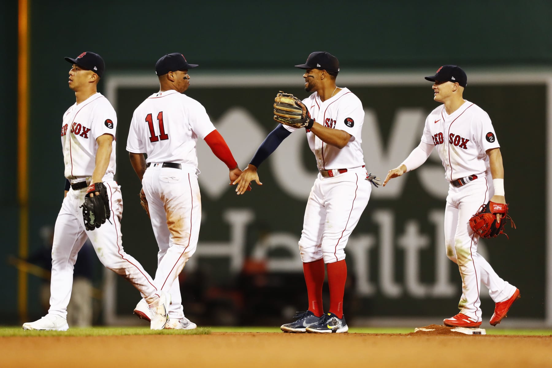 BOSTON, MASSACHUSETTS - SEPTEMBER 27: Xander Bogaerts #2 of the Boston Red Sox celebrates with teammate Rafael Devers #11 after the victory over the Baltimore Orioles at Fenway Park on September 27, 2022 in Boston, Massachusetts. (Photo by Omar Rawlings/Getty Images)