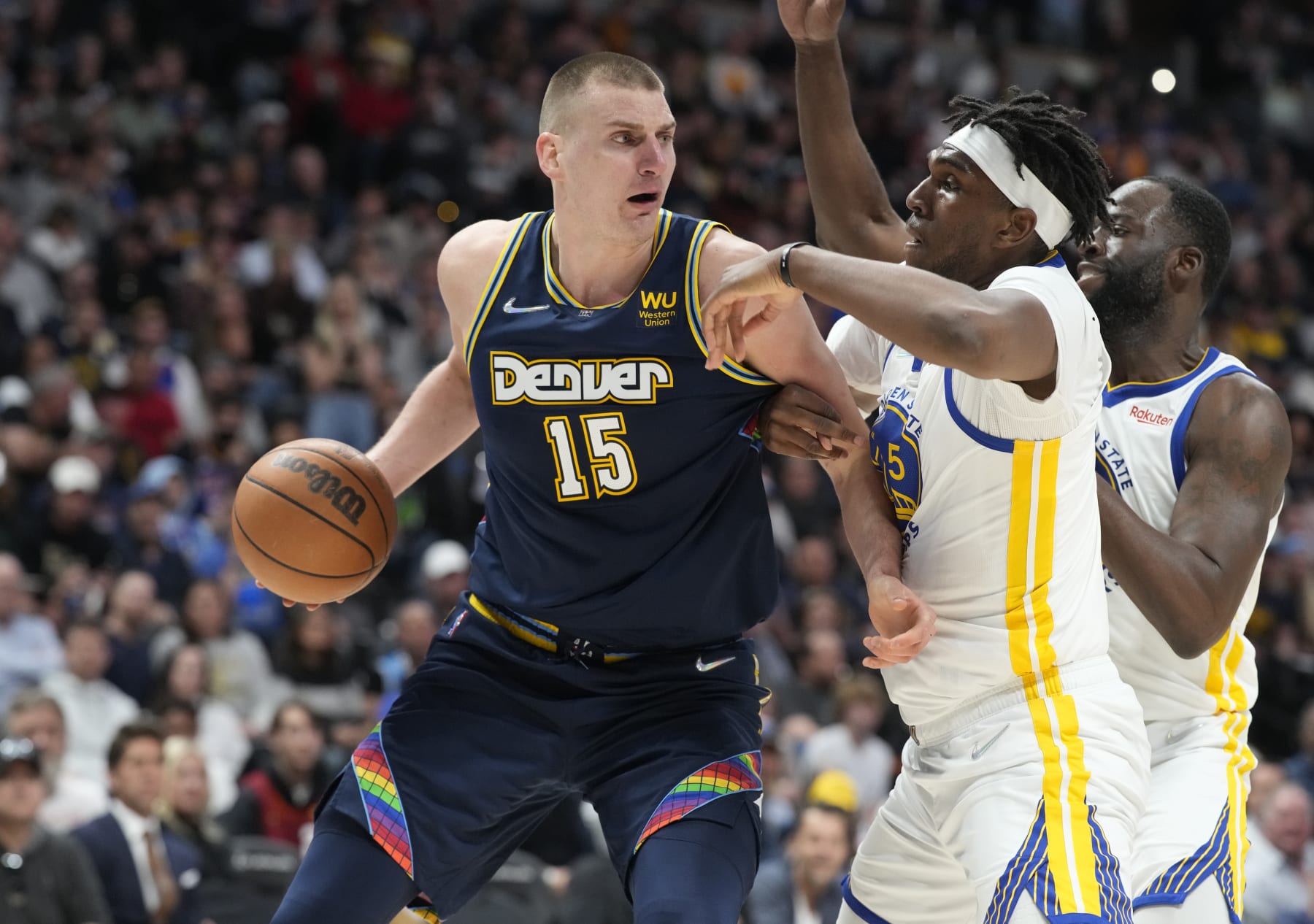 Denver Nuggets center Nikola Jokic, left, looks to pass the ball as Golden State Warriors center Kevon Looney, center, and forward Draymond Green defend in the second half of Game 4 of an NBA basketball first-round Western Conference playoff series Sunday, April 24, 2022, in Denver. (AP Photo/David Zalubowski) Denver Nuggets center Nikola Jokic, left, looks to pass the ball as Golden State Warriors center Kevon Looney, center, and forward Draymond Green defend in the second half of Game 4 of an NBA basketball first-round Western Conference playoff series Sunday, April 24, 2022, in Denver. (AP Photo/David Zalubowski)