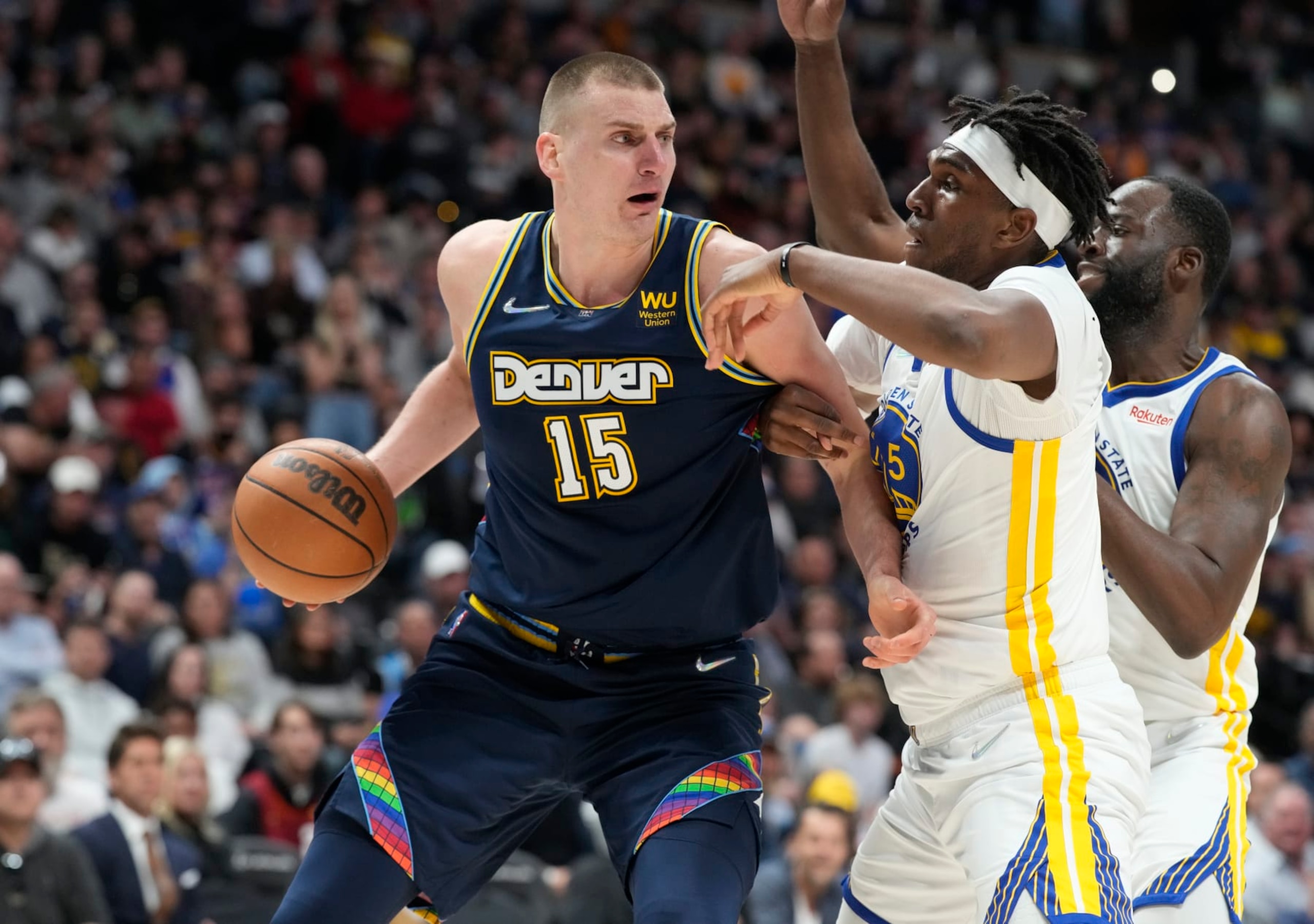 Denver Nuggets center Nikola Jokic, left, looks to pass the ball as Golden State Warriors center Kevon Looney, center, and forward Draymond Green defend in the second half of Game 4 of an NBA basketball first-round Western Conference playoff series Sunday, April 24, 2022, in Denver. (AP Photo/David Zalubowski) Denver Nuggets center Nikola Jokic, left, looks to pass the ball as Golden State Warriors center Kevon Looney, center, and forward Draymond Green defend in the second half of Game 4 of an NBA basketball first-round Western Conference playoff series Sunday, April 24, 2022, in Denver. (AP Photo/David Zalubowski)