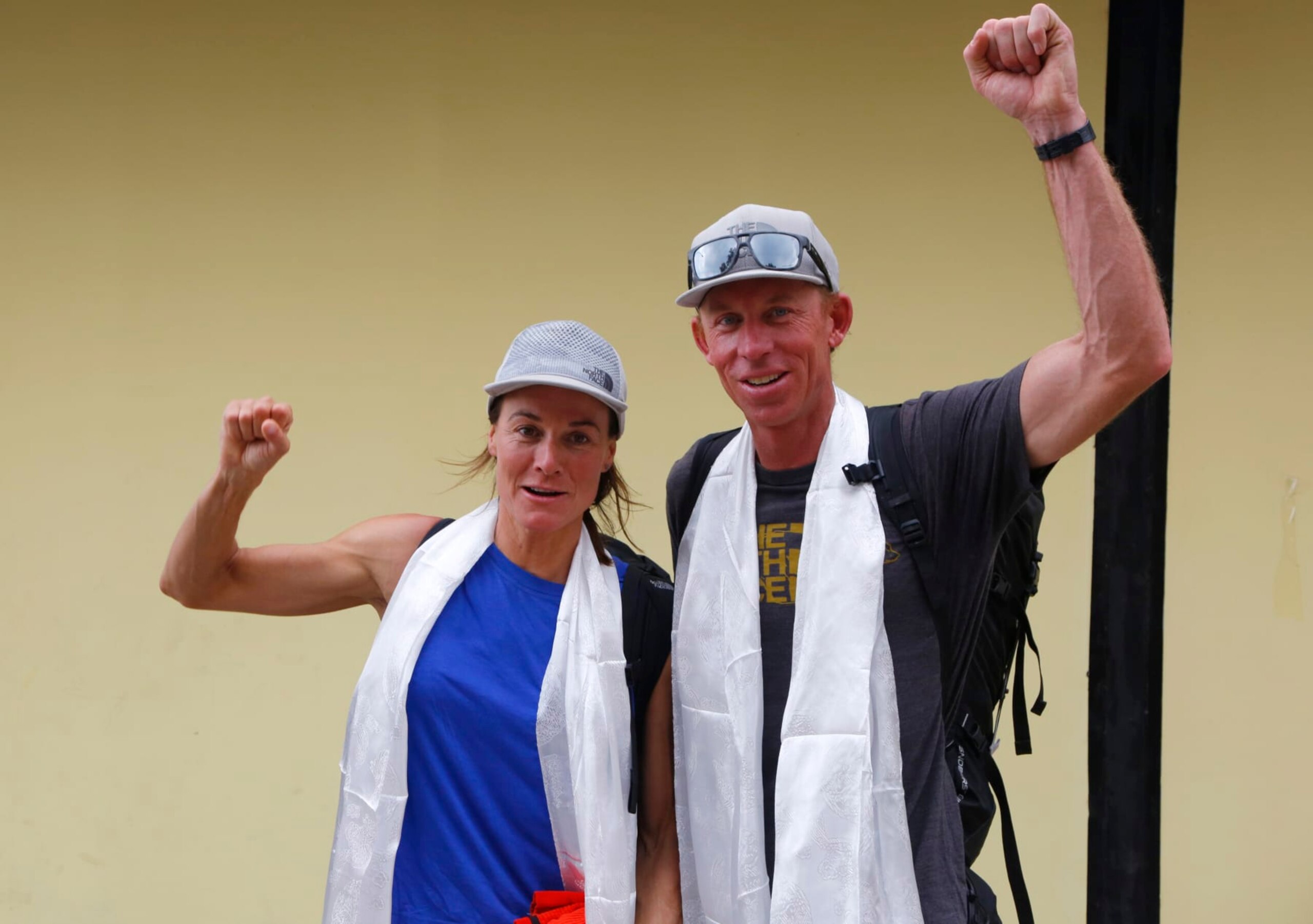 FILE- Hilaree Nelson of Telluride, Colorado, left and James Morrison of Tahoe, California, raise their fists as the pair arrived in Kathmandu, Nepal, Oct. 4, 2018. Rescuers in a helicopter were searching on the world's eighth-highest mountain Tuesday for Nelson, the famed U.S. ski mountaineer a day after she fell off the mountain near the peak. Nelson, 49, was skiing down from the 8,163-meter (26,775-foot) summit with her partner Jim Morrison when she fell off the mountain, according to Jiban Ghimire of the Kathmandu-based Shangri-La Nepal Trek that organized and outfitted the expedition.(AP Photo/Niranjan Shrestha, File)