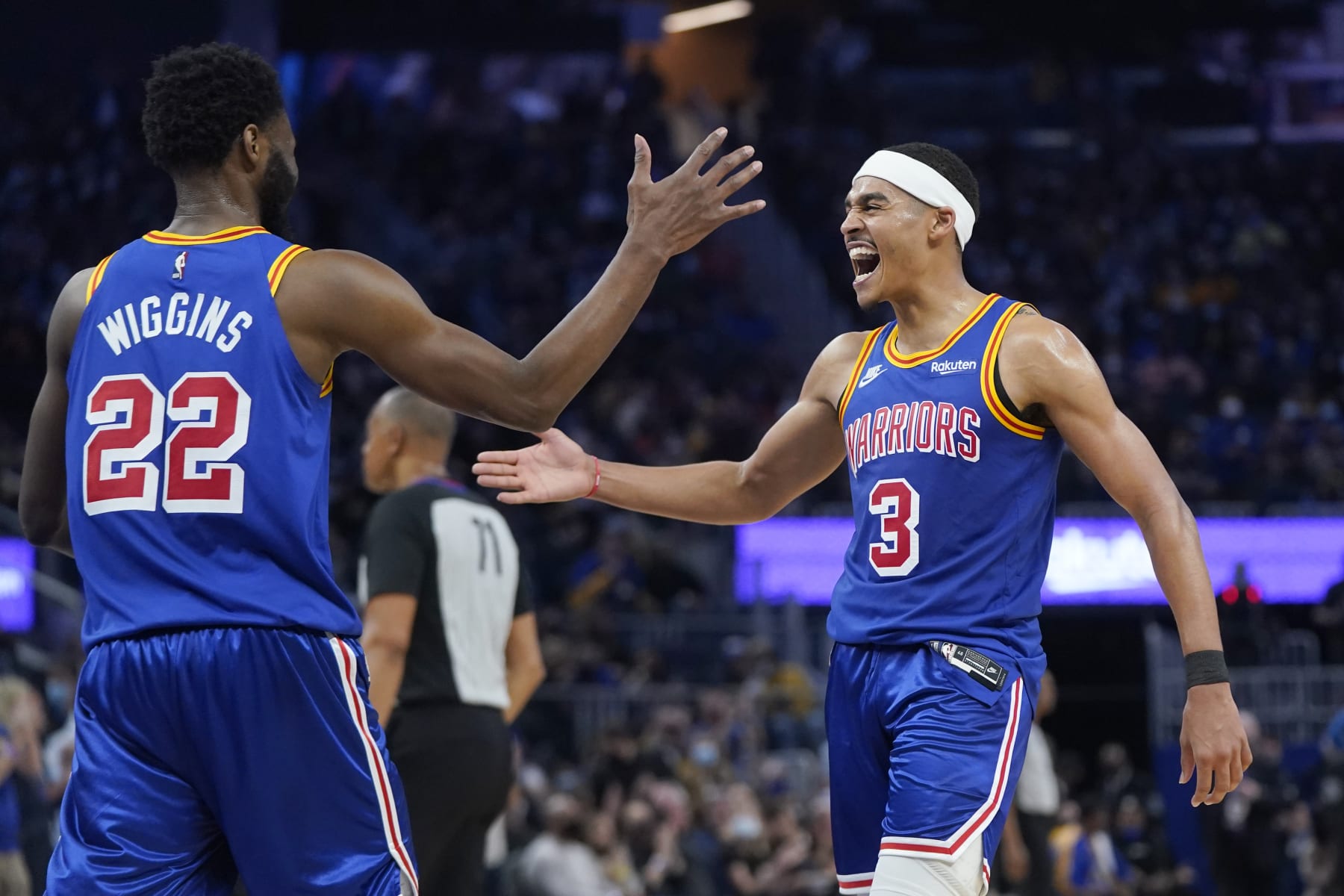 Golden State Warriors forward Andrew Wiggins (22) reacts after shooting a 3-point basket with guard Jordan Poole (3) during an NBA basketball game against the Orlando Magic in San Francisco, Monday, Dec. 6, 2021. (AP Photo/Jeff Chiu)