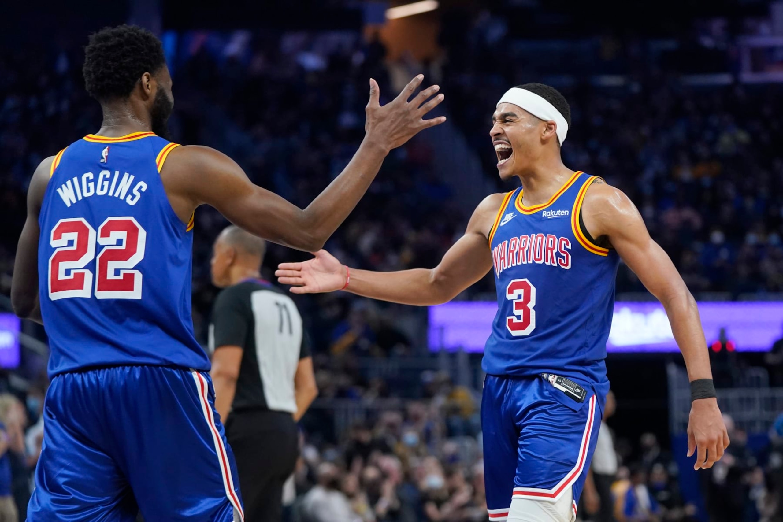 Golden State Warriors forward Andrew Wiggins (22) reacts after shooting a 3-point basket with guard Jordan Poole (3) during an NBA basketball game against the Orlando Magic in San Francisco, Monday, Dec. 6, 2021. (AP Photo/Jeff Chiu)