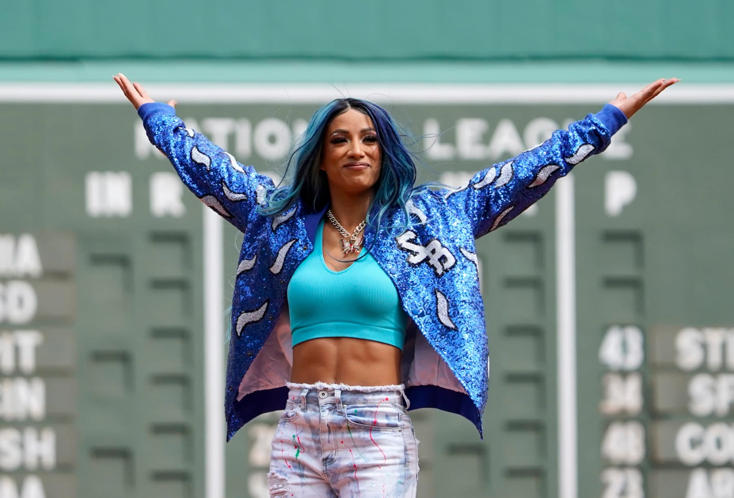 WWE wrestler Sasha Banks reacts before throwing out the first pitch before the start of baseball game between the Boston Red Sox and the Chicago White Sox at Fenway Park, Sunday, May 8, 2022, in Boston. (AP Photo/Mary Schwalm)