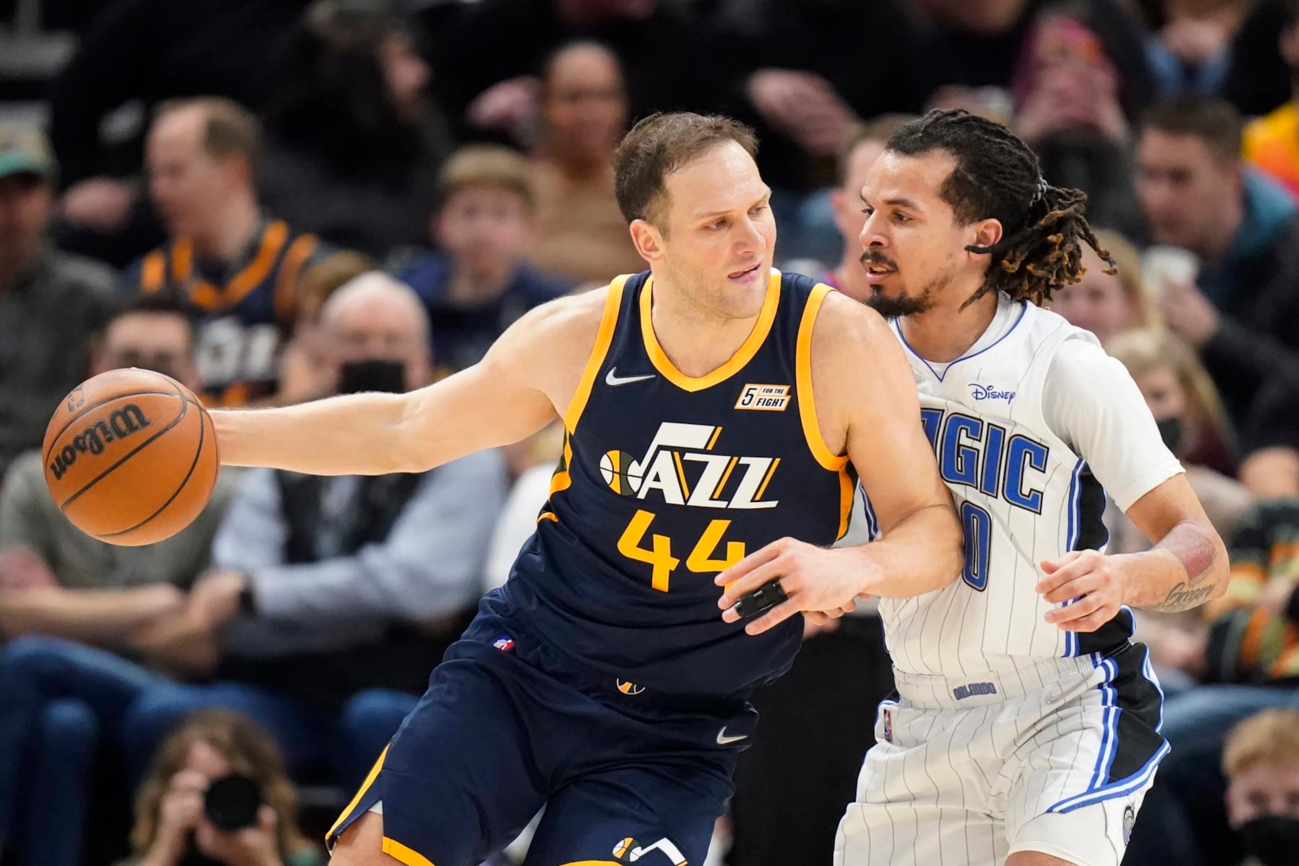 Orlando Magic guard Cole Anthony, right, guards Utah Jazz forward Bojan Bogdanovic (44) in the first half during an NBA basketball game Friday, Feb. 11, 2022, in Salt Lake City. (AP Photo/Rick Bowmer)