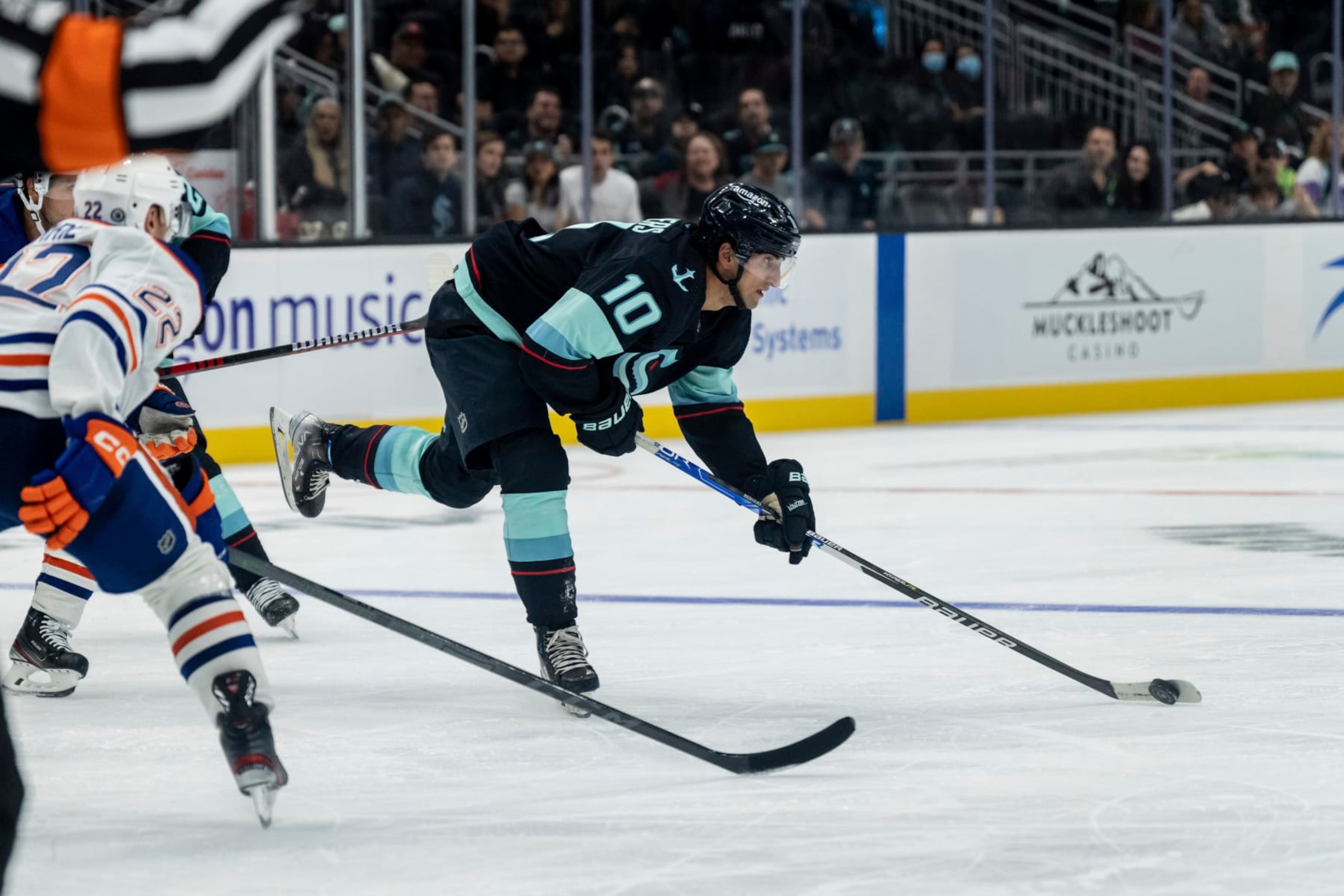 Seattle Kraken forward Matty Beniers skates against defenseman Tyson Barrie during the third period of a preseason NHL hockey game, Monday, Sept. 26, 2022, in Seattle. The Kraken won 3-0. (AP Photo/Stephen Brashear)