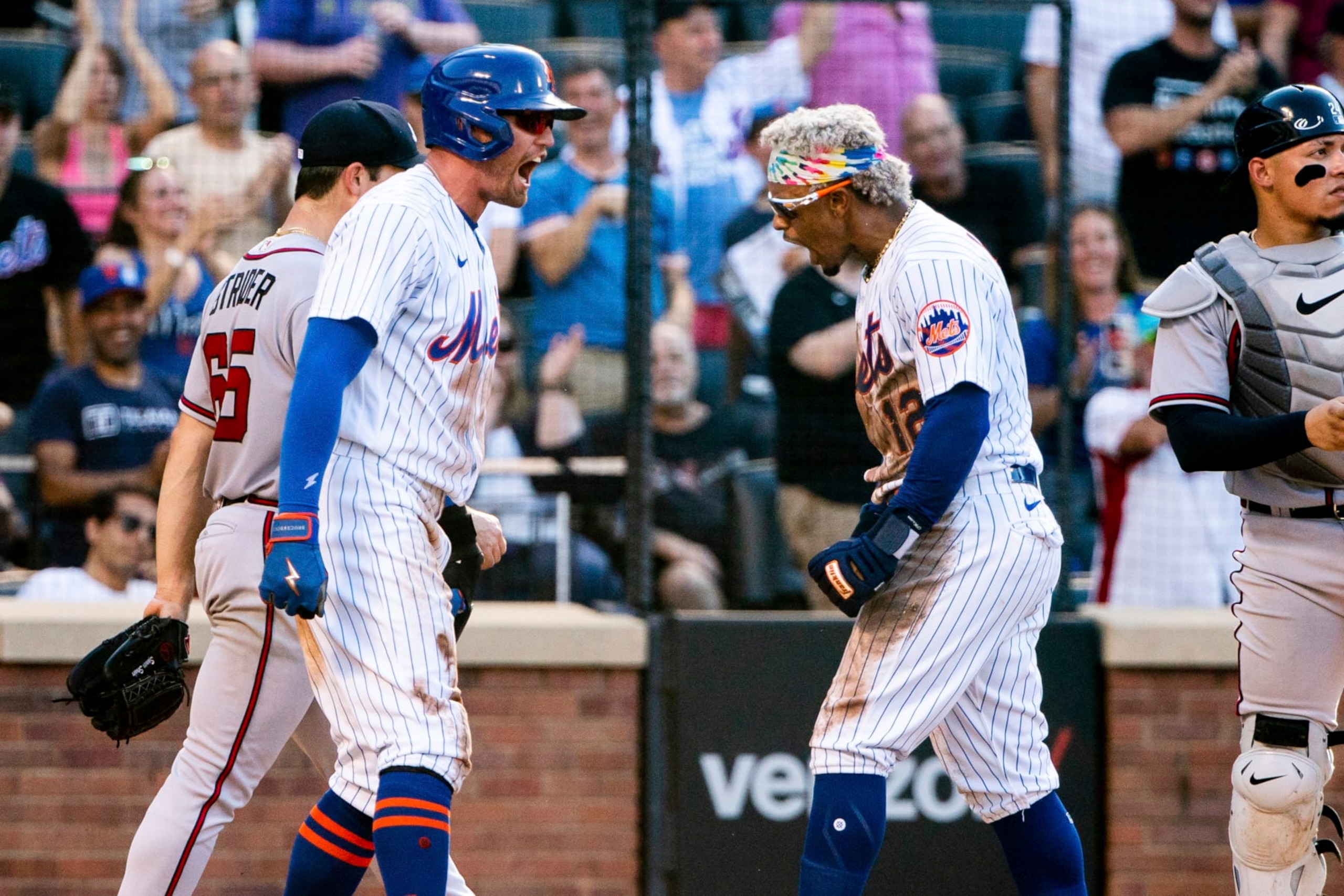 New York Mets' Brandon Nimmo and Francisco Lindor celebrate after scoring during the third inning of a baseball game against the Atlanta Braves, Sunday, Aug. 7, 2022, in New York. (AP Photo/Julia Nikhinson)