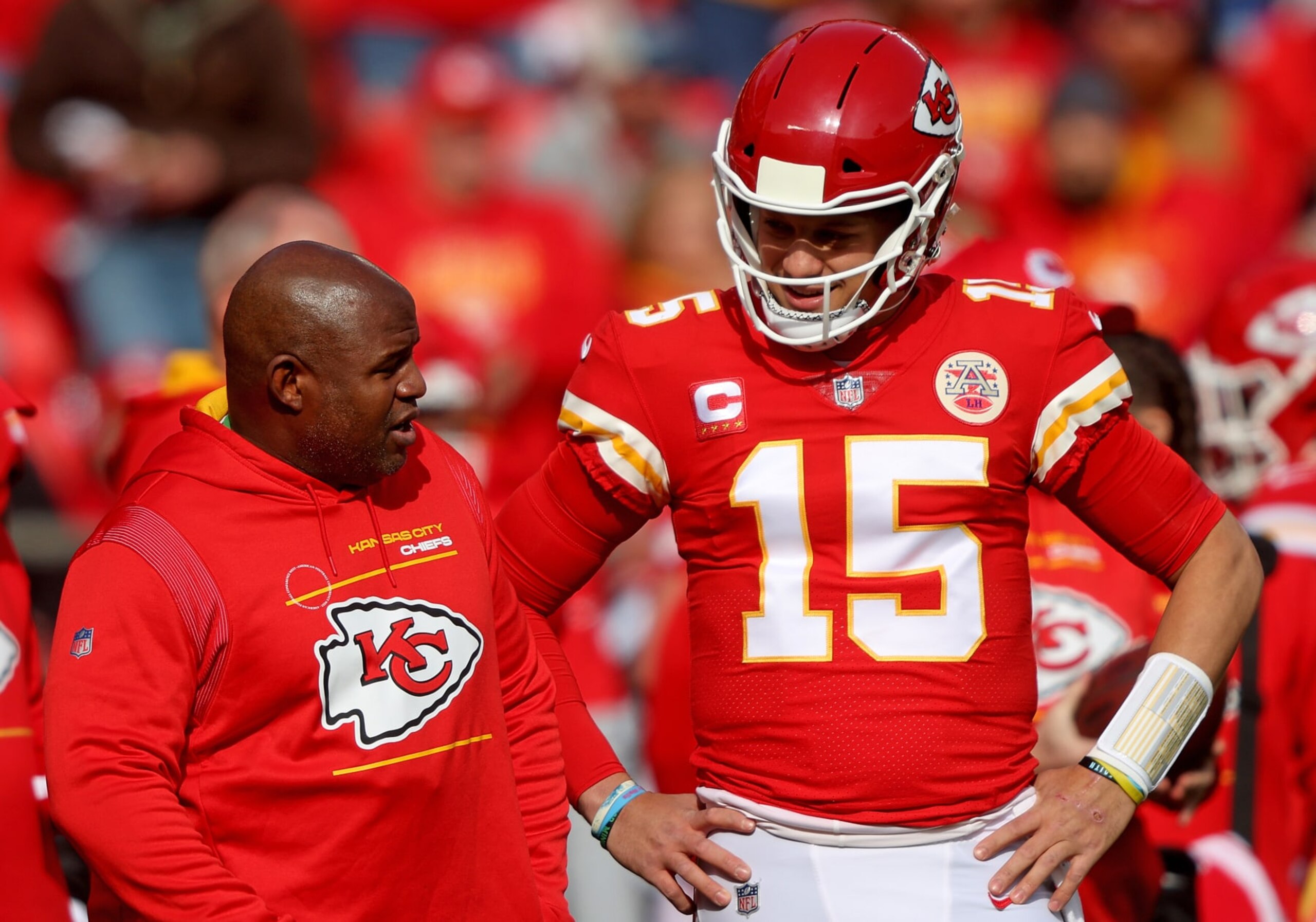 KANSAS CITY, MISSOURI - JANUARY 30: Quarterback Patrick Mahomes #15 of the Kansas City Chiefs talks with offensive coordinator Eric Bieniemy during the AFC Championship Game 	against the Cincinnati Bengals at Arrowhead Stadium on January 30, 2022 in Kansas City, Missouri. (Photo by Jamie Squire/Getty Images)