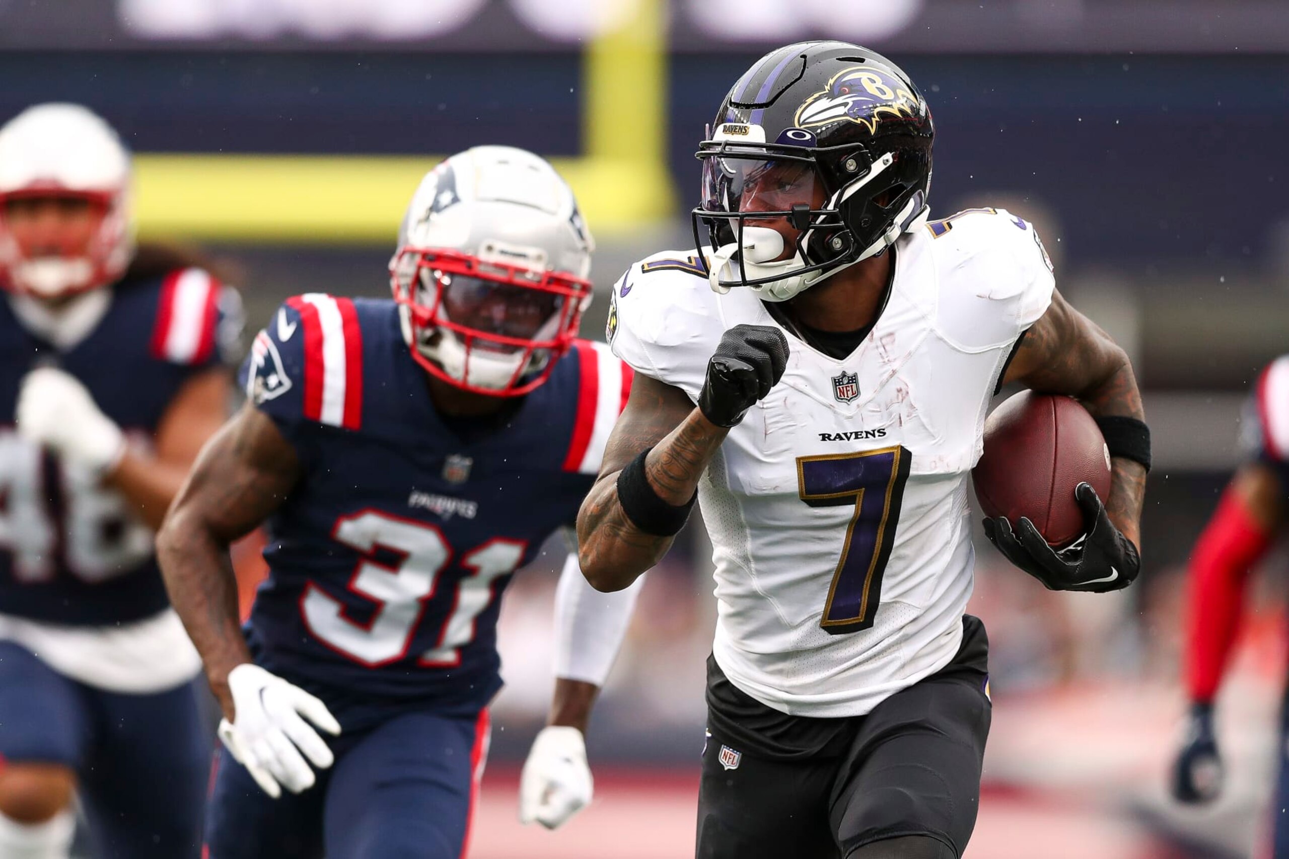 FOXBOROUGH, MASSACHUSETTS - SEPTEMBER 25: Wide receiver Rashod Bateman #7 of the Baltimore Ravens runs upfield while cornerback Jonathan Jones #31 of the New England Patriots pursues during the fourth quarter at Gillette Stadium on September 25, 2022 in Foxborough, Massachusetts. (Photo by Adam Glanzman/Getty Images)