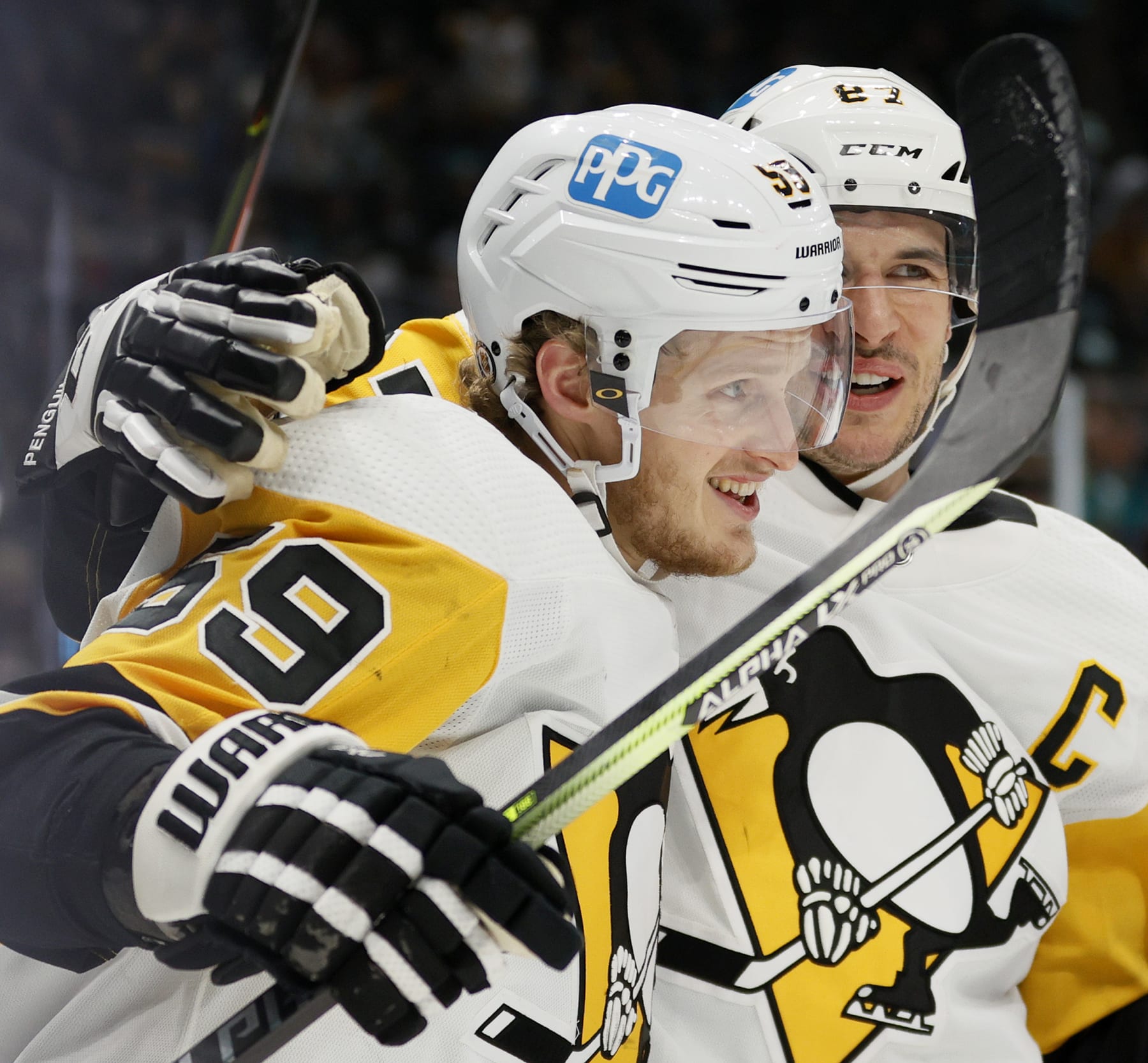 SEATTLE, WASHINGTON - DECEMBER 06: Jake Guentzel #59 celebrates his goal with Sidney Crosby #87 of the Pittsburgh Penguins during the third period against the Seattle Kraken at Climate Pledge Arena on December 06, 2021 in Seattle, Washington. (Photo by Steph Chambers/Getty Images)