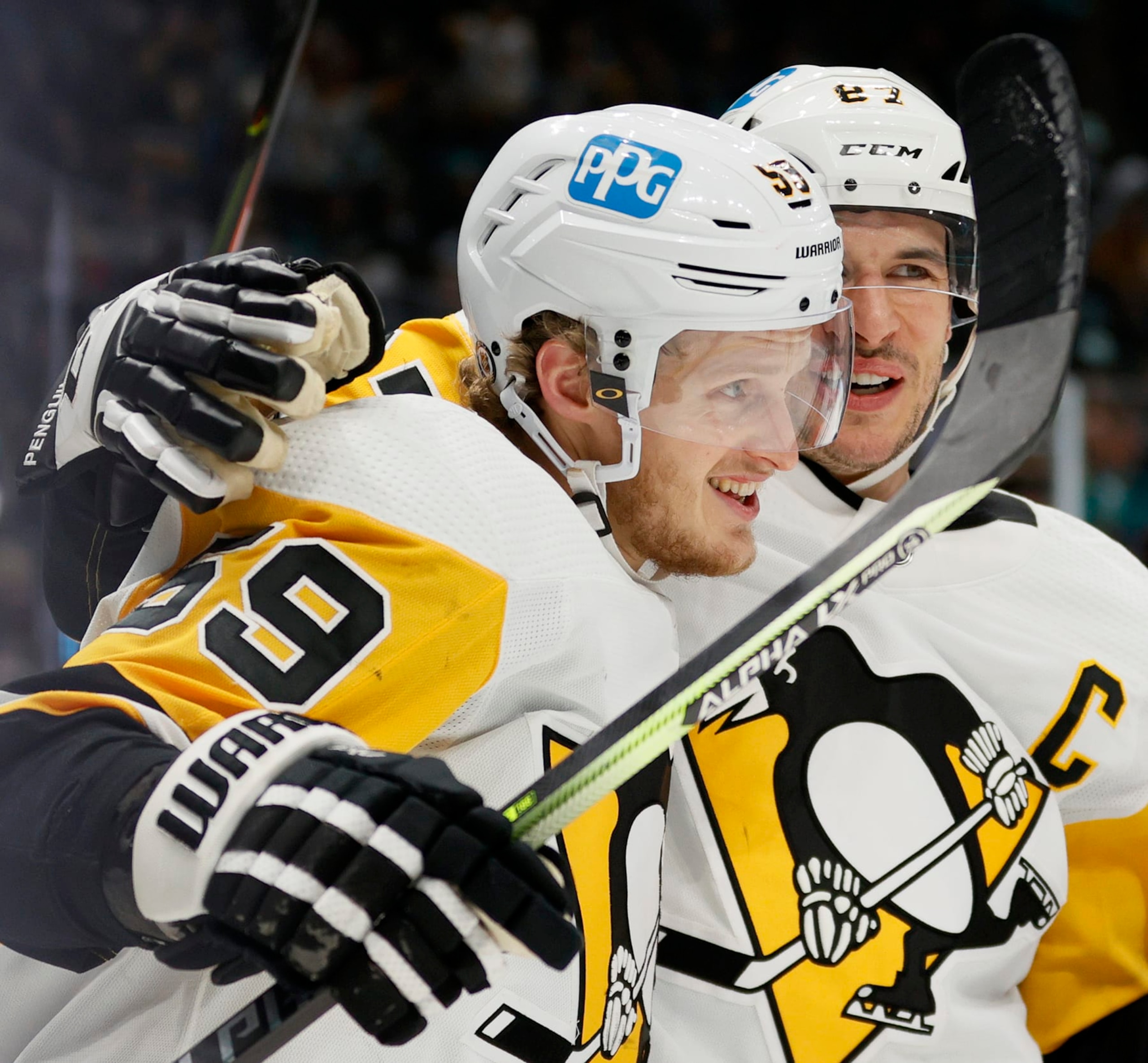 SEATTLE, WASHINGTON - DECEMBER 06: Jake Guentzel #59 celebrates his goal with Sidney Crosby #87 of the Pittsburgh Penguins during the third period against the Seattle Kraken at Climate Pledge Arena on December 06, 2021 in Seattle, Washington. (Photo by Steph Chambers/Getty Images)