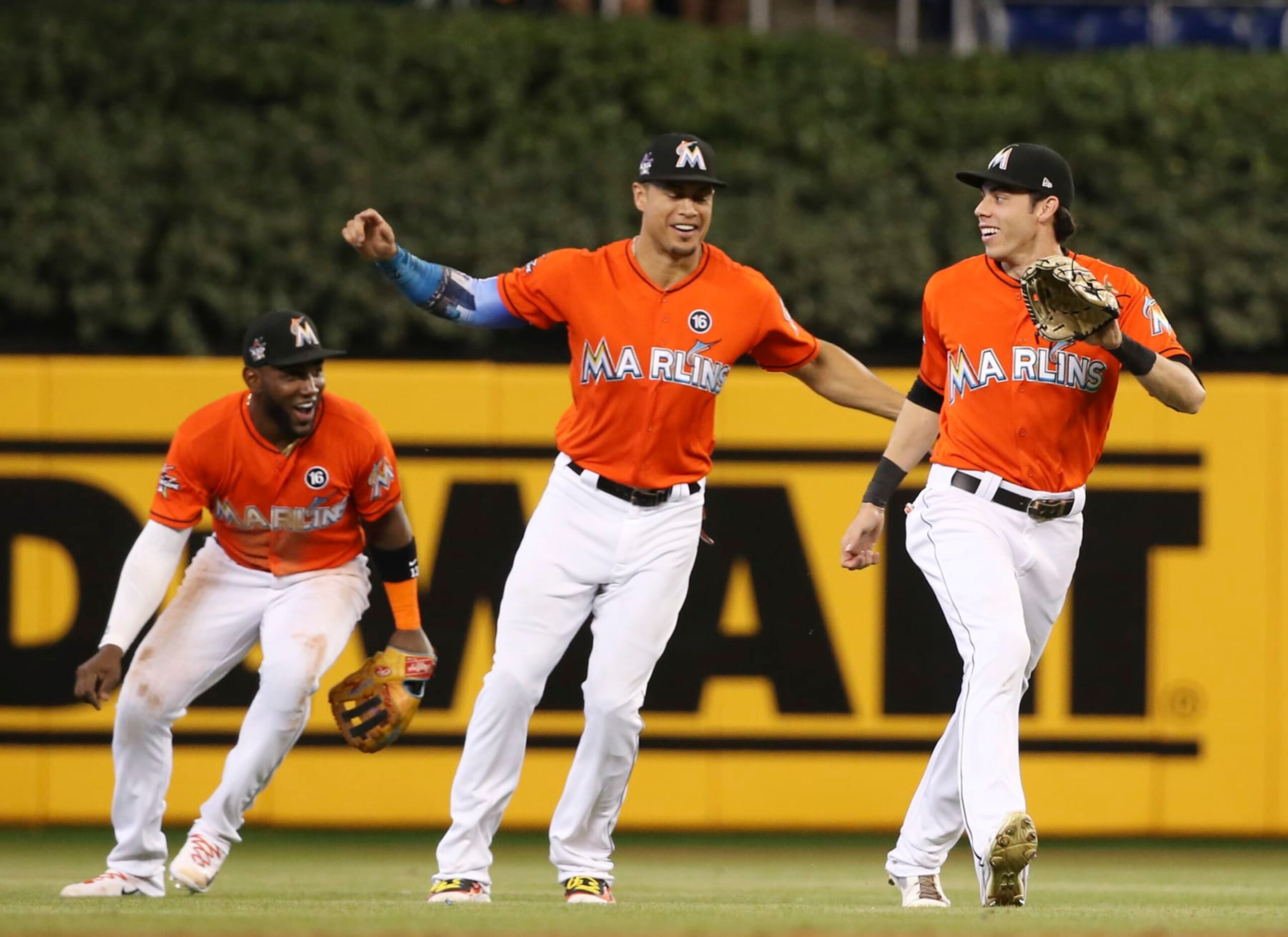 Miami Marlins center fielder Christian Yelich, right, right fielder Giancarlo Stanton, center, and left fielder Marcell Ozuna, left, celebrate after they defeated the Colorado Rockies in a baseball game, Sunday, Aug. 13, 2017, in Miami. (AP Photo/Wilfredo Lee)