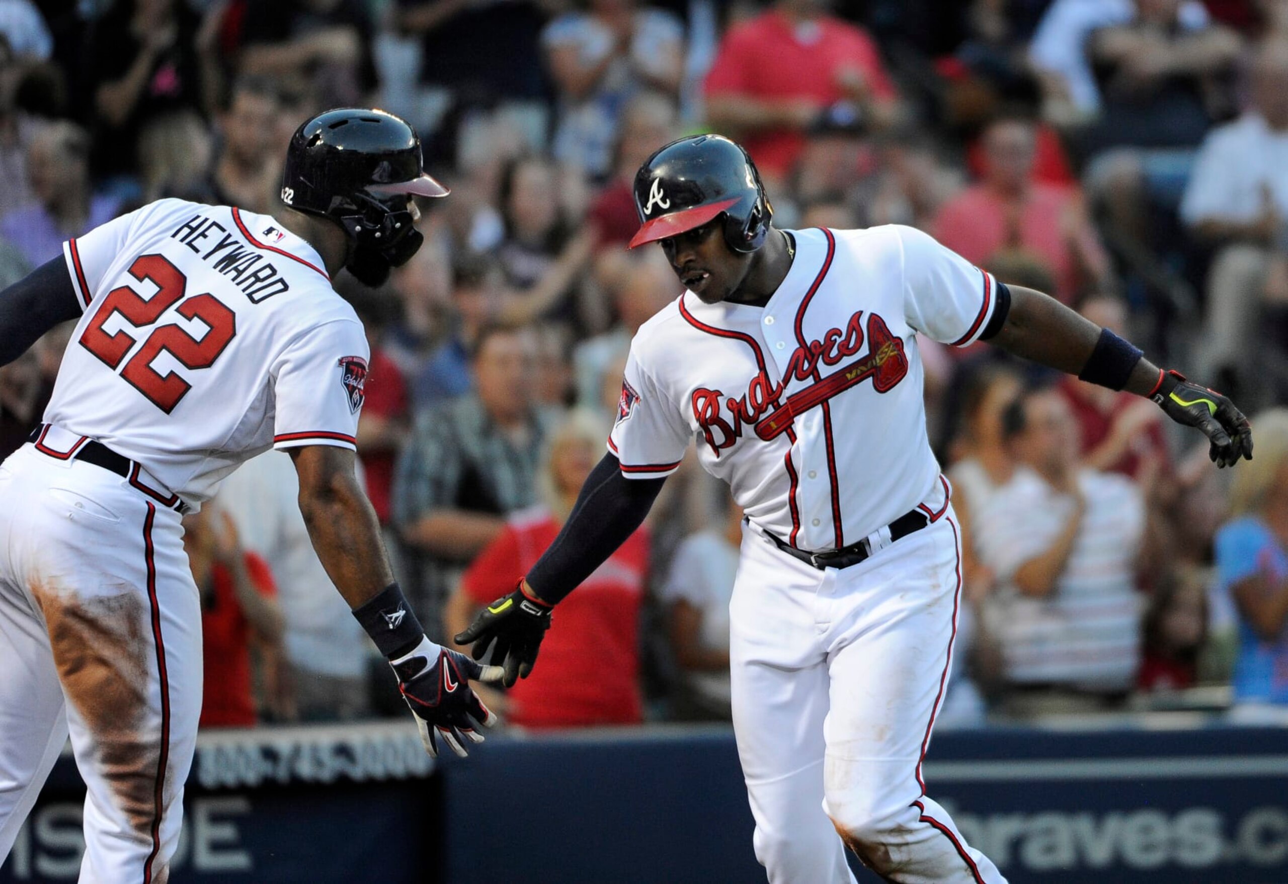 Atlanta Braves' Justin Upton, right, celebrates with Jason Heyward after Upton hit a solo home run against the Miami Marlins during the third inning of a baseball game Tuesday, July 22, 2014, in Atlanta. (AP Photo/David Tulis)