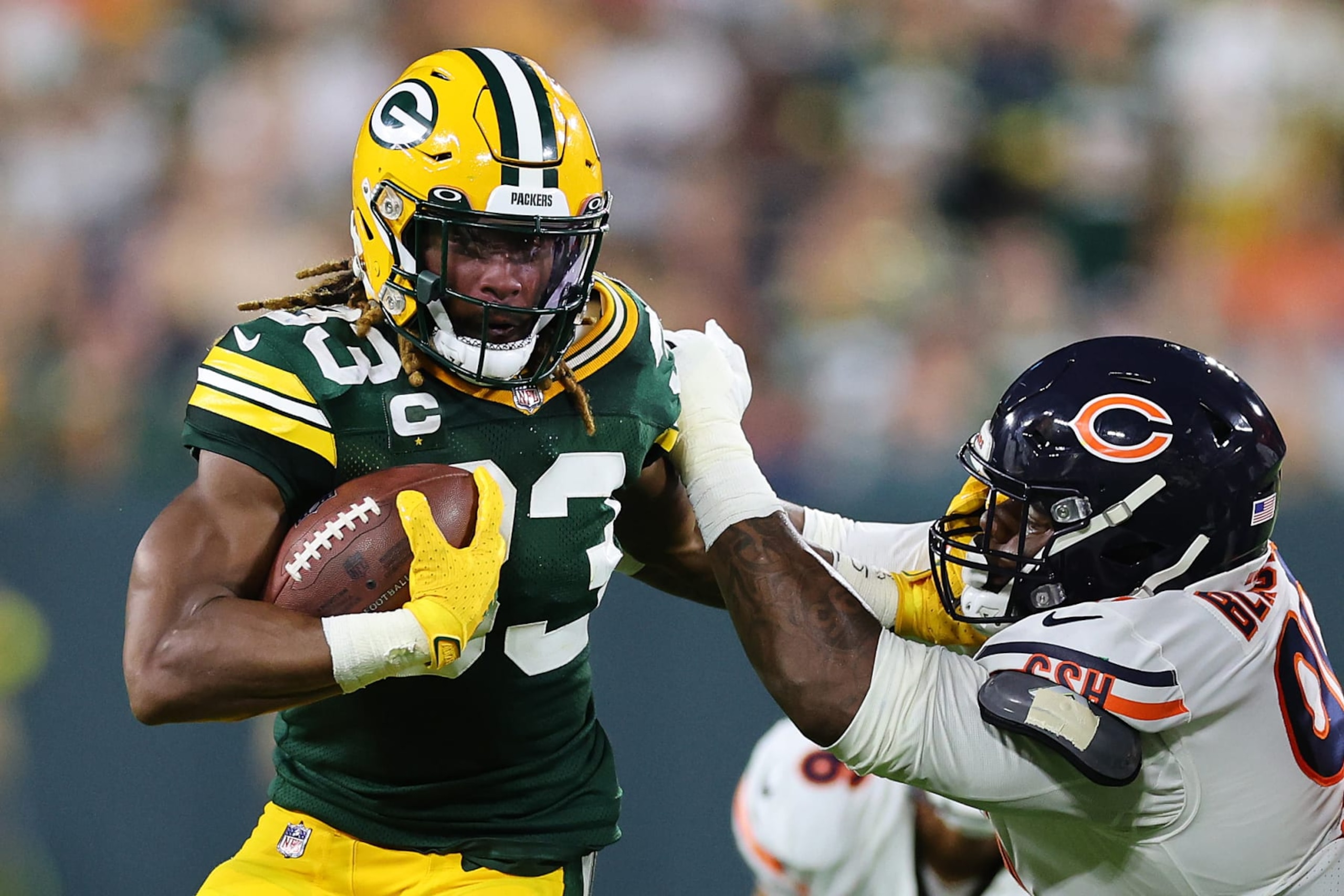 GREEN BAY, WISCONSIN - SEPTEMBER 18: Aaron Jones #33 of the Green Bay Packers stiffs arms Angelo Blackson #90 of the Chicago Bears at Lambeau Field on September 18, 2022 in Green Bay, Wisconsin. (Photo by Michael Reaves/Getty Images)