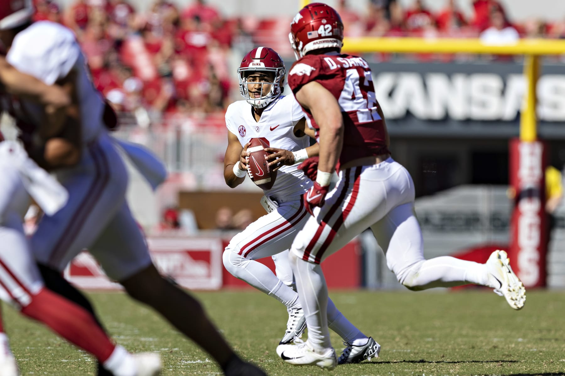 FAYETTEVILLE, ARKANSAS - OCTOBER 01: Bryce Young #9 of the Alabama Crimson Tide rolls out looking for a receiver in the first half and is pressured by Drew Sanders #42 of the Arkansas Razorbacks at Donald W. Reynolds Razorback Stadium on October 01, 2022 in Fayetteville, Arkansas. (Photo by Wesley Hitt/Getty Images)