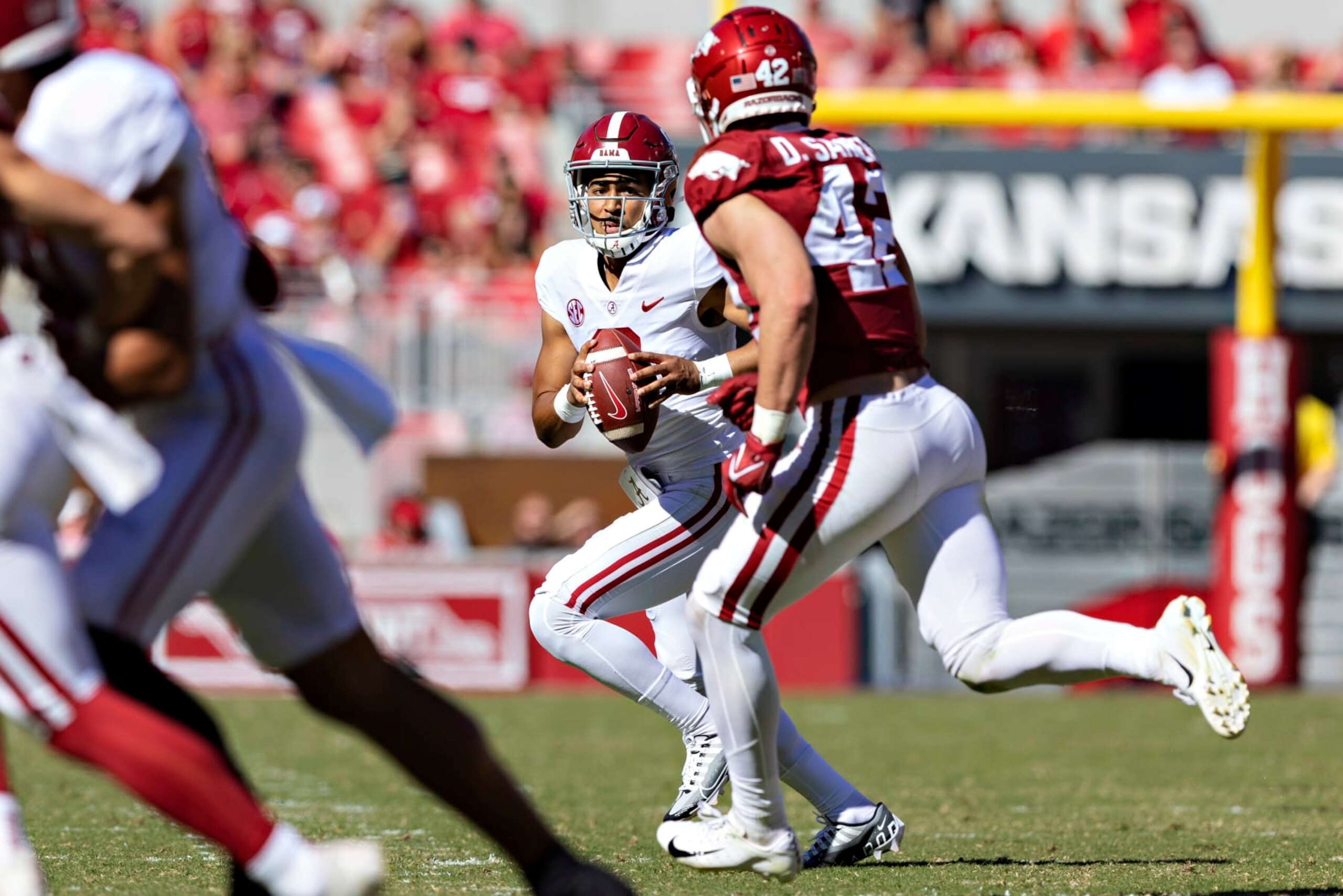 FAYETTEVILLE, ARKANSAS - OCTOBER 01: Bryce Young #9 of the Alabama Crimson Tide rolls out looking for a receiver in the first half and is pressured by Drew Sanders #42 of the Arkansas Razorbacks at Donald W. Reynolds Razorback Stadium on October 01, 2022 in Fayetteville, Arkansas. (Photo by Wesley Hitt/Getty Images)