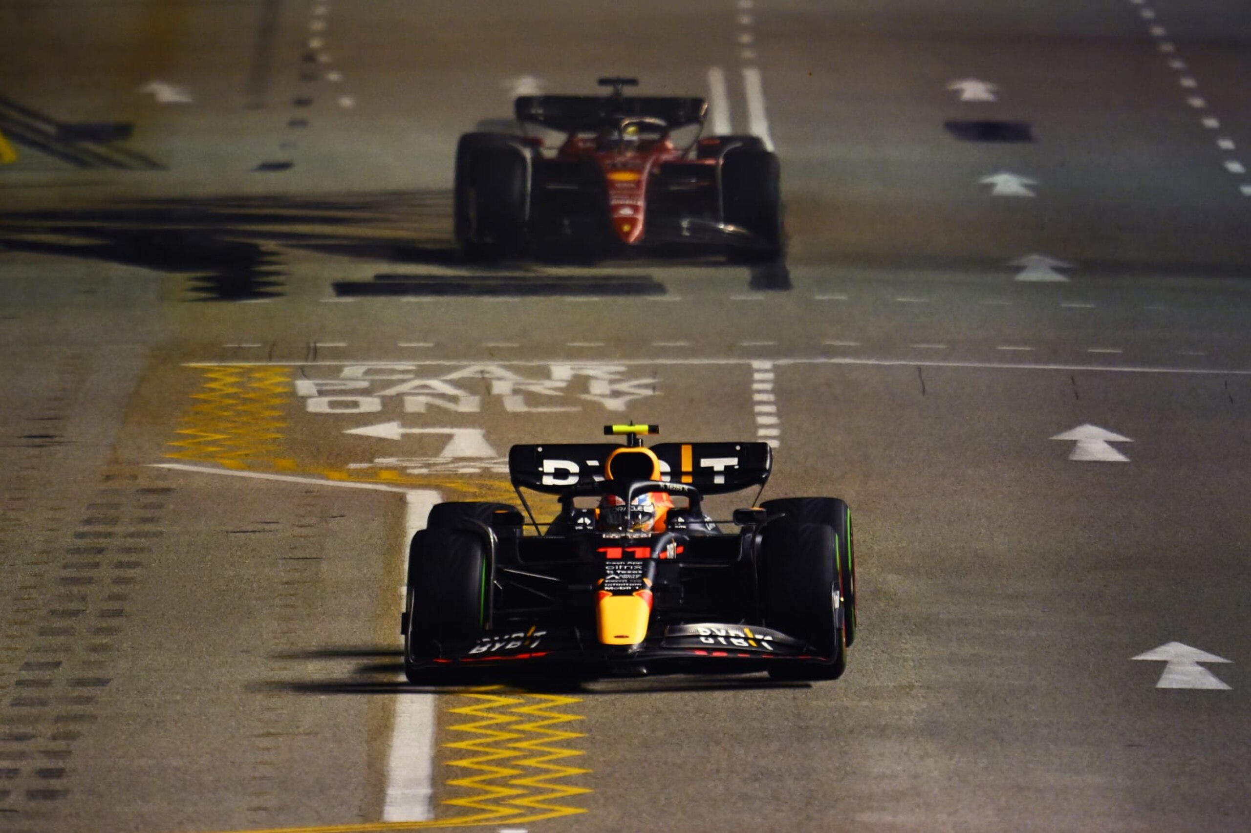 SINGAPORE, SINGAPORE - OCTOBER 02: Sergio Perez of Mexico driving the (11) Oracle Red Bull Racing RB18 leads Charles Leclerc of Monaco driving the (16) Ferrari F1-75 during the F1 Grand Prix of Singapore at Marina Bay Street Circuit on October 02, 2022 in Singapore, Singapore. (Photo by Clive Mason/Getty Images,)