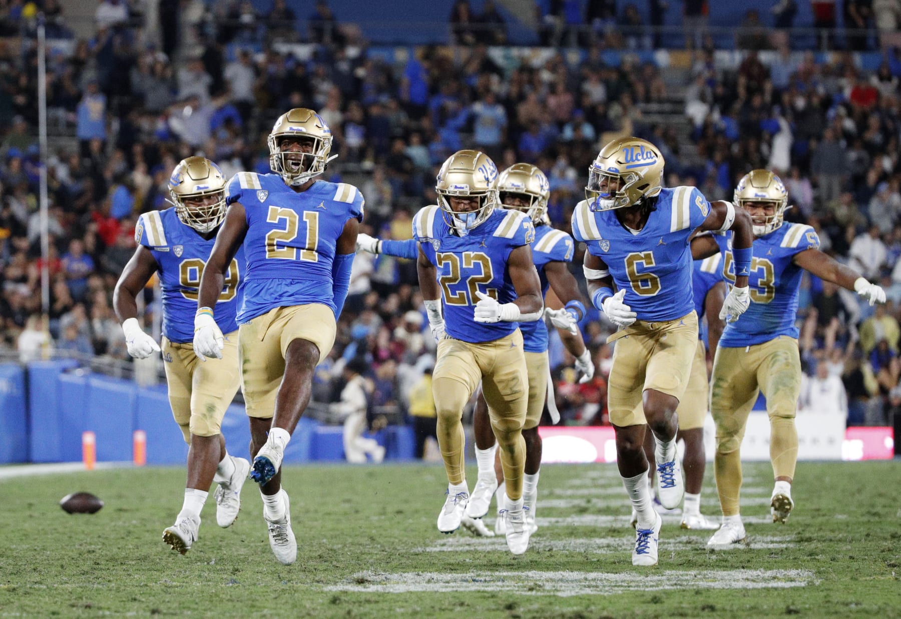 PASADENA, CA - SEPTEMBER 30, 2022: UCLA Bruins linebacker JonJon Vaughns (21) high-steps down the field with teammates after intercepting a pass from Washington Huskies quarterback Michael Penix Jr. in the second quarter at the Rose Bowl on September 30, 2022 in Pasadena, California.(Gina Ferazzi / Los Angeles Times via Getty Images)
