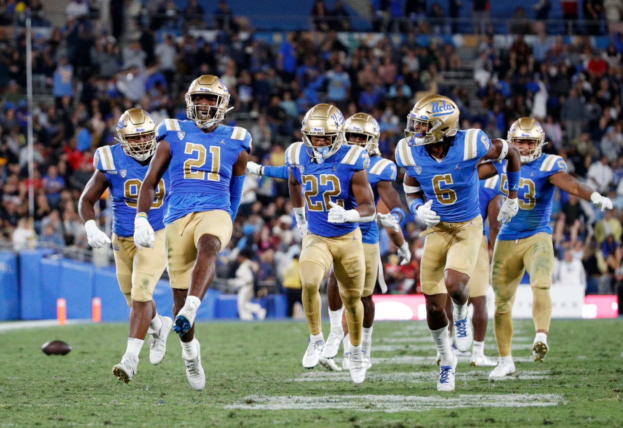 PASADENA, CA - SEPTEMBER 30, 2022: UCLA Bruins linebacker JonJon Vaughns (21) high-steps down the field with teammates after intercepting a pass from Washington Huskies quarterback Michael Penix Jr. in the second quarter at the Rose Bowl on September 30, 2022 in Pasadena, California.(Gina Ferazzi / Los Angeles Times via Getty Images)