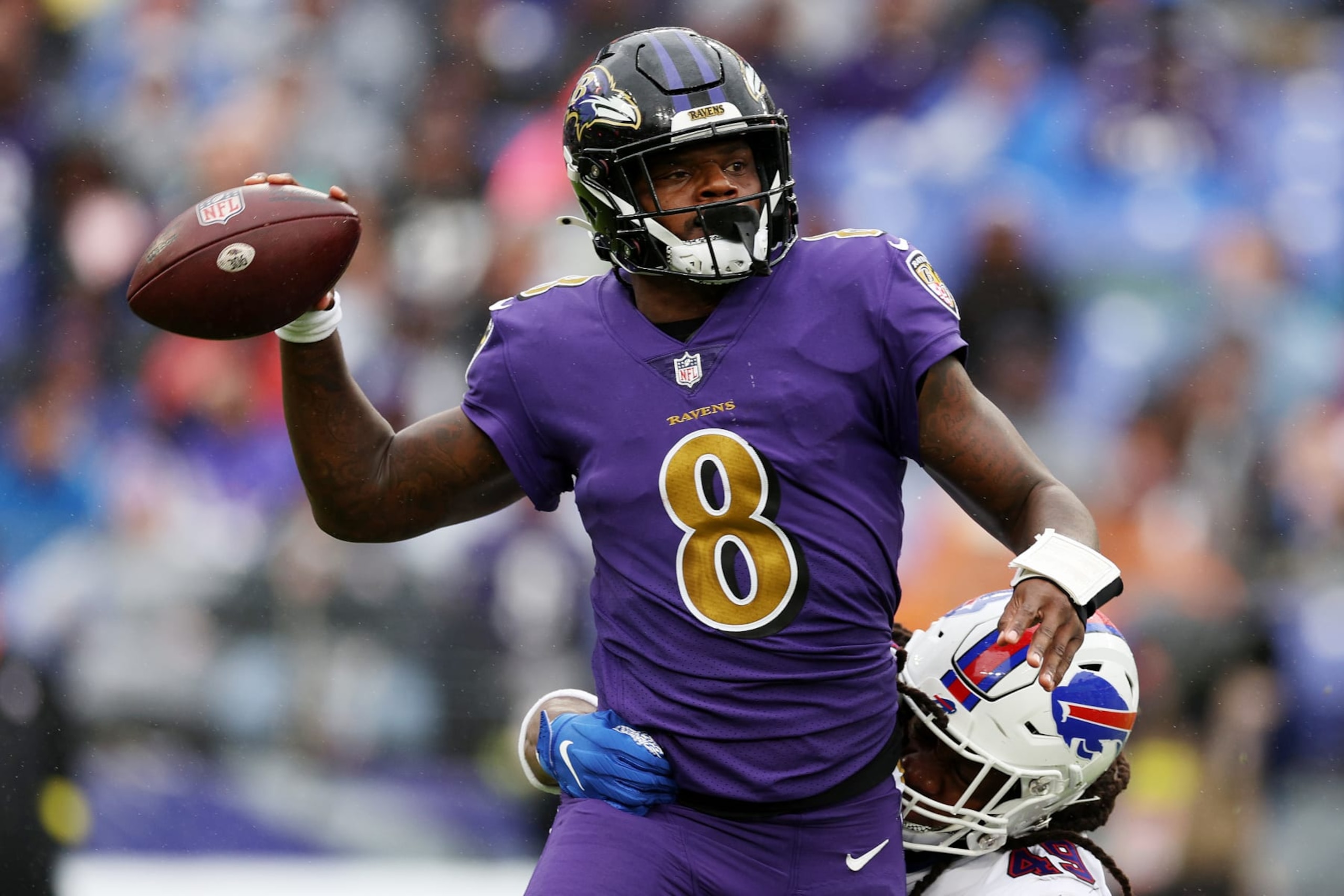 BALTIMORE, MARYLAND - OCTOBER 02: Lamar Jackson #8 of the Baltimore Ravens throws a pass while being tackled by Tremaine Edmunds #49 of the Buffalo Bills in the third quarter at M&T Bank Stadium on October 02, 2022 in Baltimore, Maryland. (Photo by Rob Carr/Getty Images)