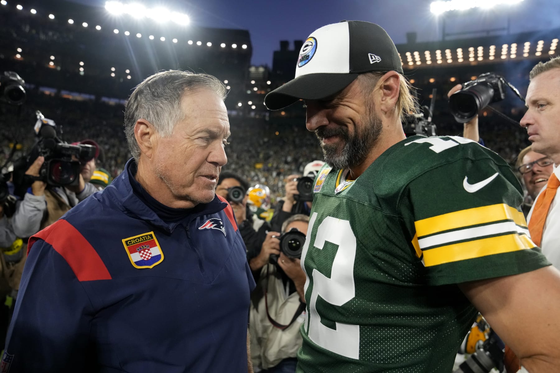 GREEN BAY, WISCONSIN - OCTOBER 02: Head coach Bill Belichick of the New England Patriots and Aaron Rodgers #12 of the Green Bay Packers talk after Green Bay's 27-24 win in overtime at Lambeau Field on October 02, 2022 in Green Bay, Wisconsin. (Photo by Patrick McDermott/Getty Images)
