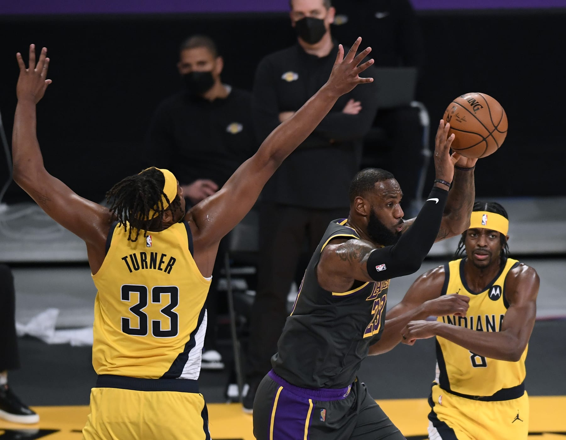 LOS ANGELES, CALIFORNIA - MARCH 12: LeBron James #23 of the Los Angeles Lakers passes between Myles Turner #33 and Justin Holiday #8 of the Indiana Pacers during the second quarter at Staples Center on March 12, 2021 in Los Angeles, California. (Photo by Harry How/Getty Images)  NOTE TO USER: User expressly acknowledges and agrees that, by downloading and/or using this Photograph, user is consenting to the terms and conditions of the Getty Images License Agreement. Mandatory Copyright Notice: Copyright 2021 NBAE.