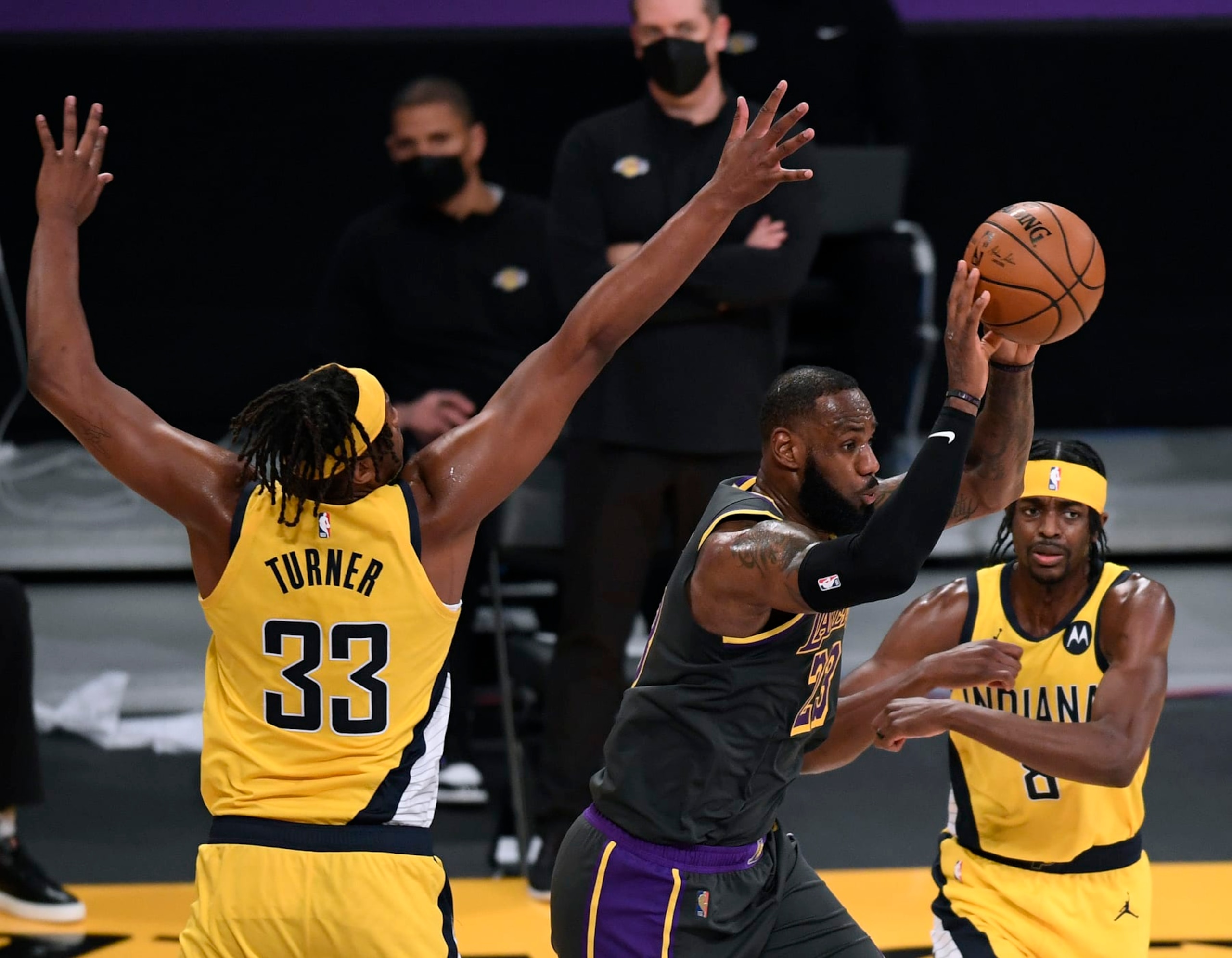 LOS ANGELES, CALIFORNIA - MARCH 12: LeBron James #23 of the Los Angeles Lakers passes between Myles Turner #33 and Justin Holiday #8 of the Indiana Pacers during the second quarter at Staples Center on March 12, 2021 in Los Angeles, California. (Photo by Harry How/Getty Images)  NOTE TO USER: User expressly acknowledges and agrees that, by downloading and/or using this Photograph, user is consenting to the terms and conditions of the Getty Images License Agreement. Mandatory Copyright Notice: Copyright 2021 NBAE.