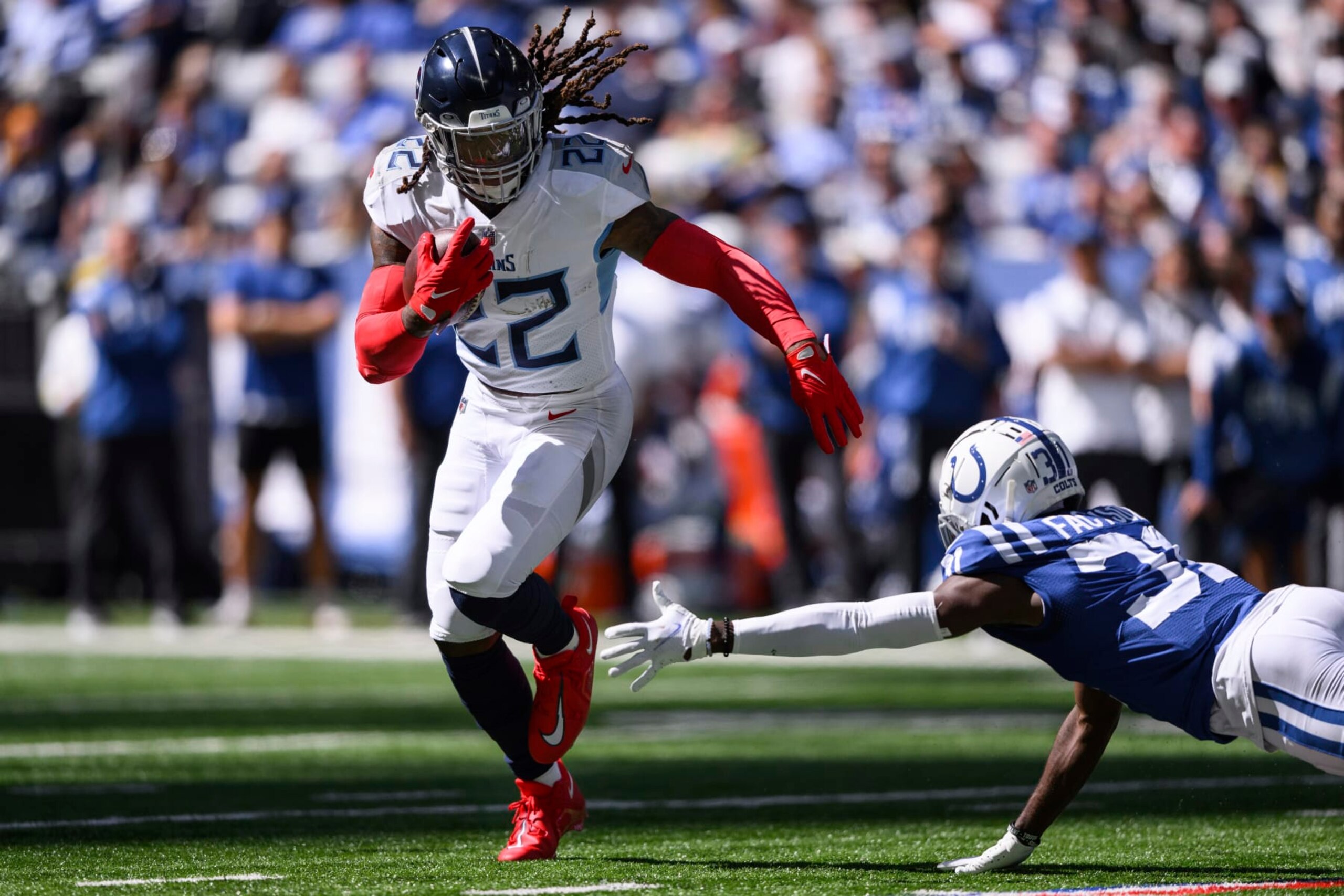 Tennessee Titans running back Derrick Henry (22) runs past Indianapolis Colts cornerback Brandon Facyson (31) during an NFL football game, Sunday, Oct. 2, 2022, in Indianapolis. (AP Photo/Zach Bolinger)