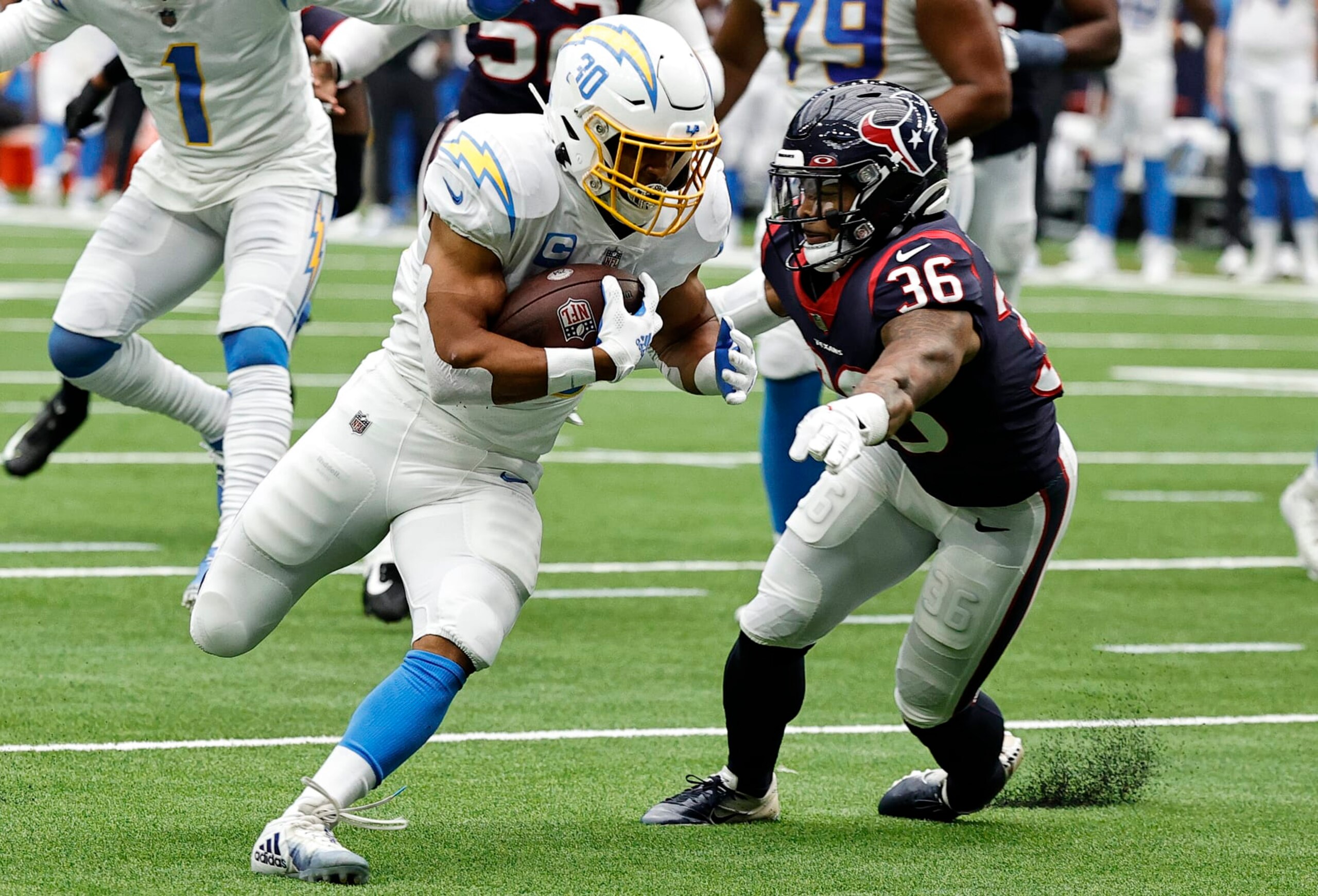 HOUSTON, TEXAS - OCTOBER 02: Austin Ekeler #30 of the Los Angeles Chargers runs with the ball while being chased by Jonathan Owens #36 of the Houston Texans in the second quarter at NRG Stadium on October 02, 2022 in Houston, Texas. (Photo by Bob Levey/Getty Images)