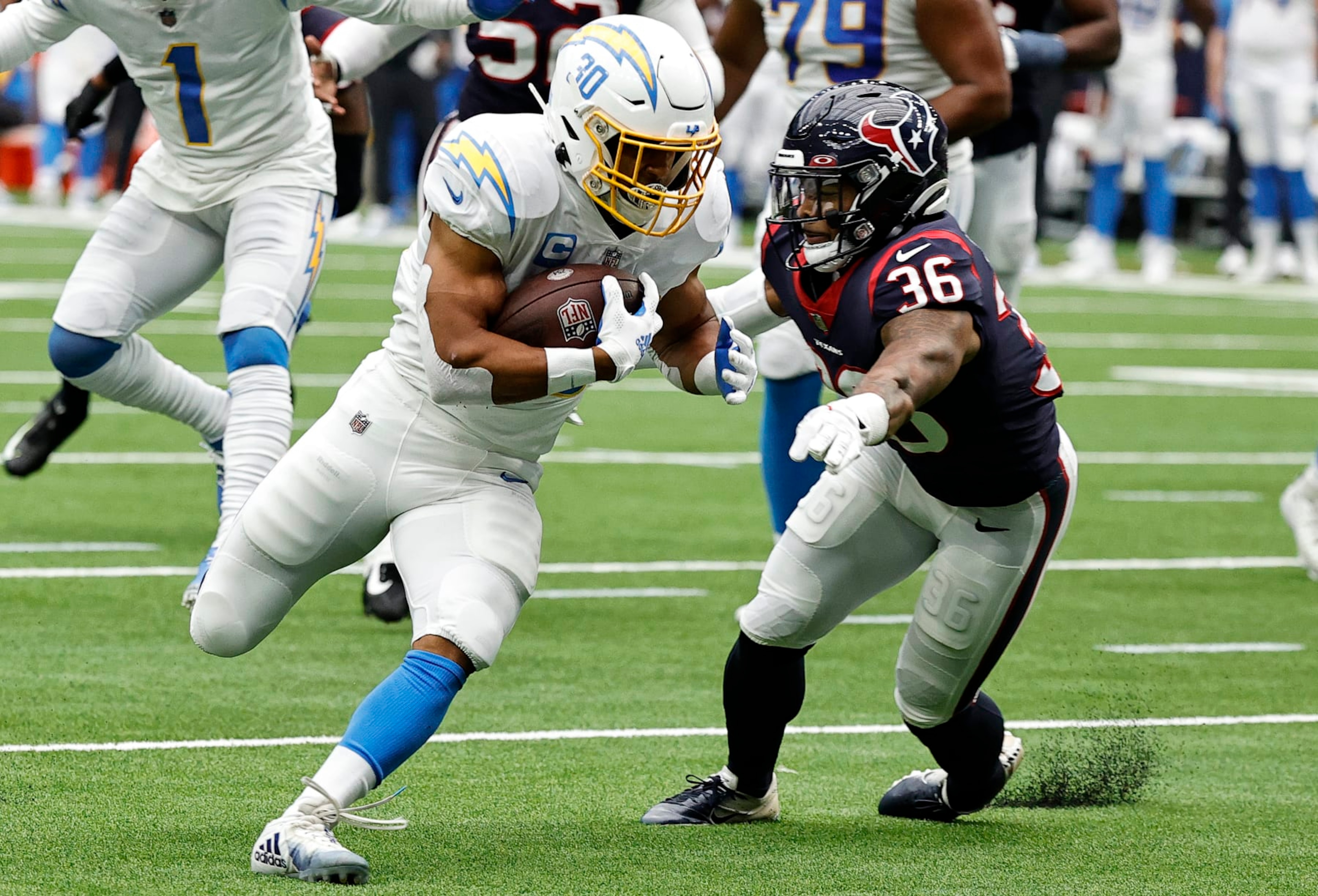 HOUSTON, TEXAS - OCTOBER 02: Austin Ekeler #30 of the Los Angeles Chargers runs with the ball while being chased by Jonathan Owens #36 of the Houston Texans in the second quarter at NRG Stadium on October 02, 2022 in Houston, Texas. (Photo by Bob Levey/Getty Images)