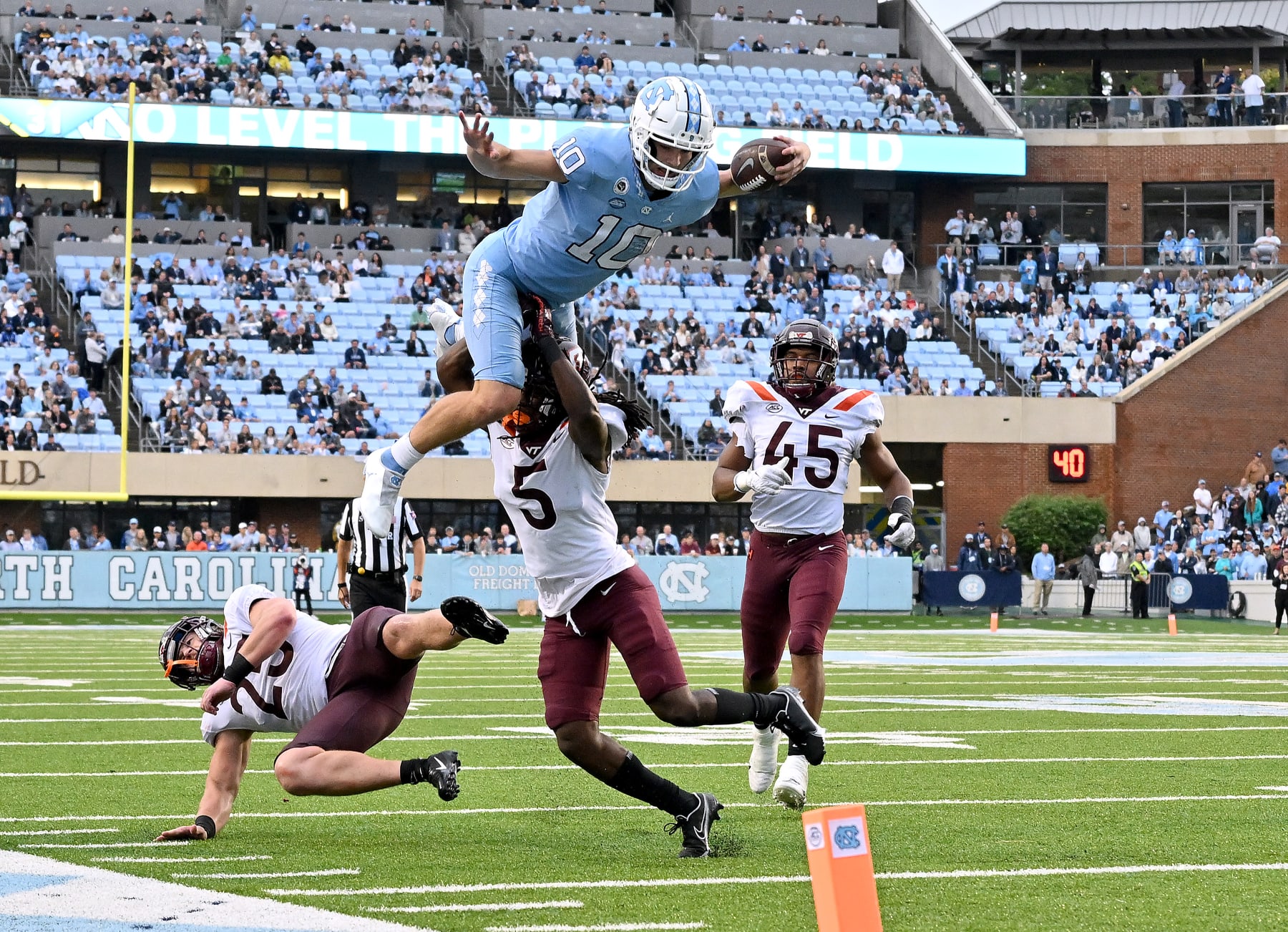 CHAPEL HILL, NORTH CAROLINA - OCTOBER 01: Drake Maye #10 of the North Carolina Tar Heels hurdles Nasir Peoples #5 of the Virginia Tech Hokies during the second half of their game at Kenan Memorial Stadium on October 01, 2022 in Chapel Hill, North Carolina. (Photo by Grant Halverson/Getty Images)