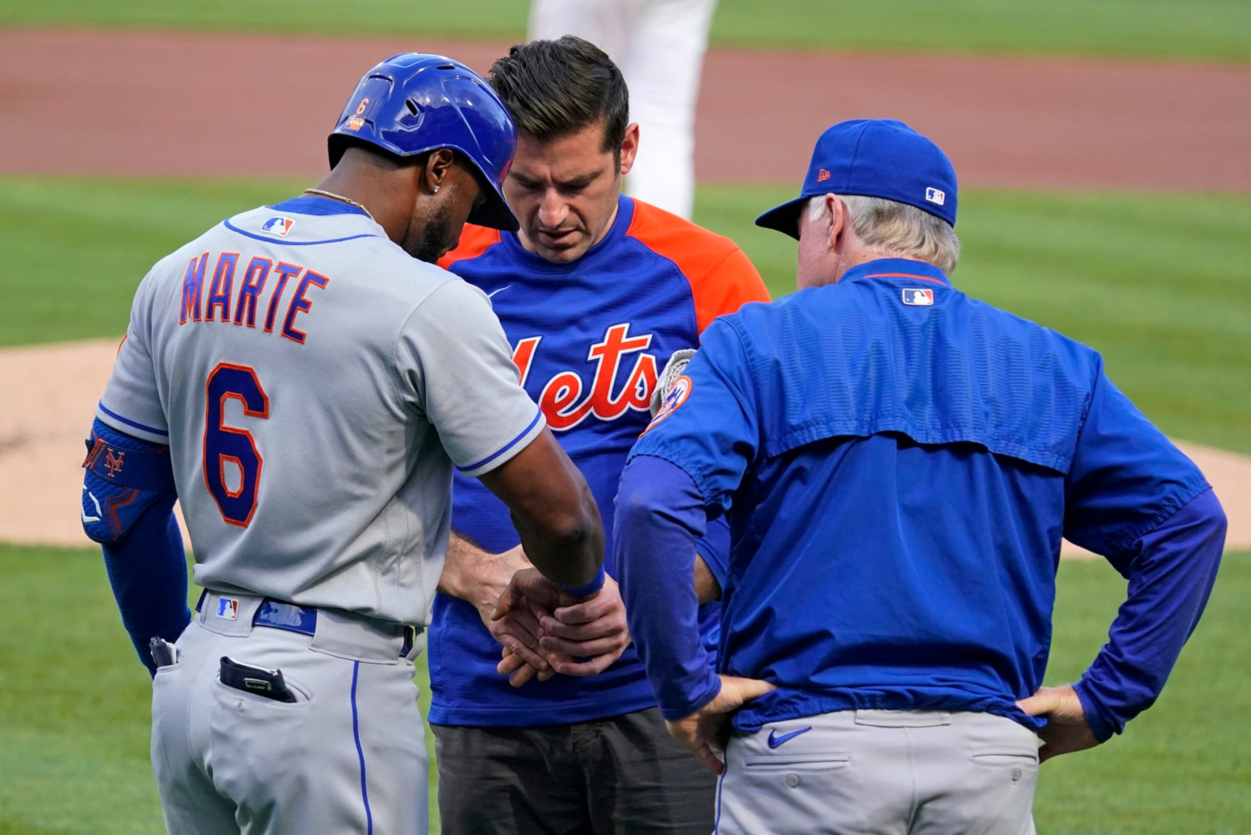 New York Mets' Starling Marte (6) is checked by a trainer with manager Buck Showalter looking on, after being hit on the hand by a pitch from Pittsburgh Pirates starting pitcher Mitch Keller during the first inning of a baseball game in Pittsburgh, Tuesday, Sept. 6, 2022. (AP Photo/Gene J. Puskar)