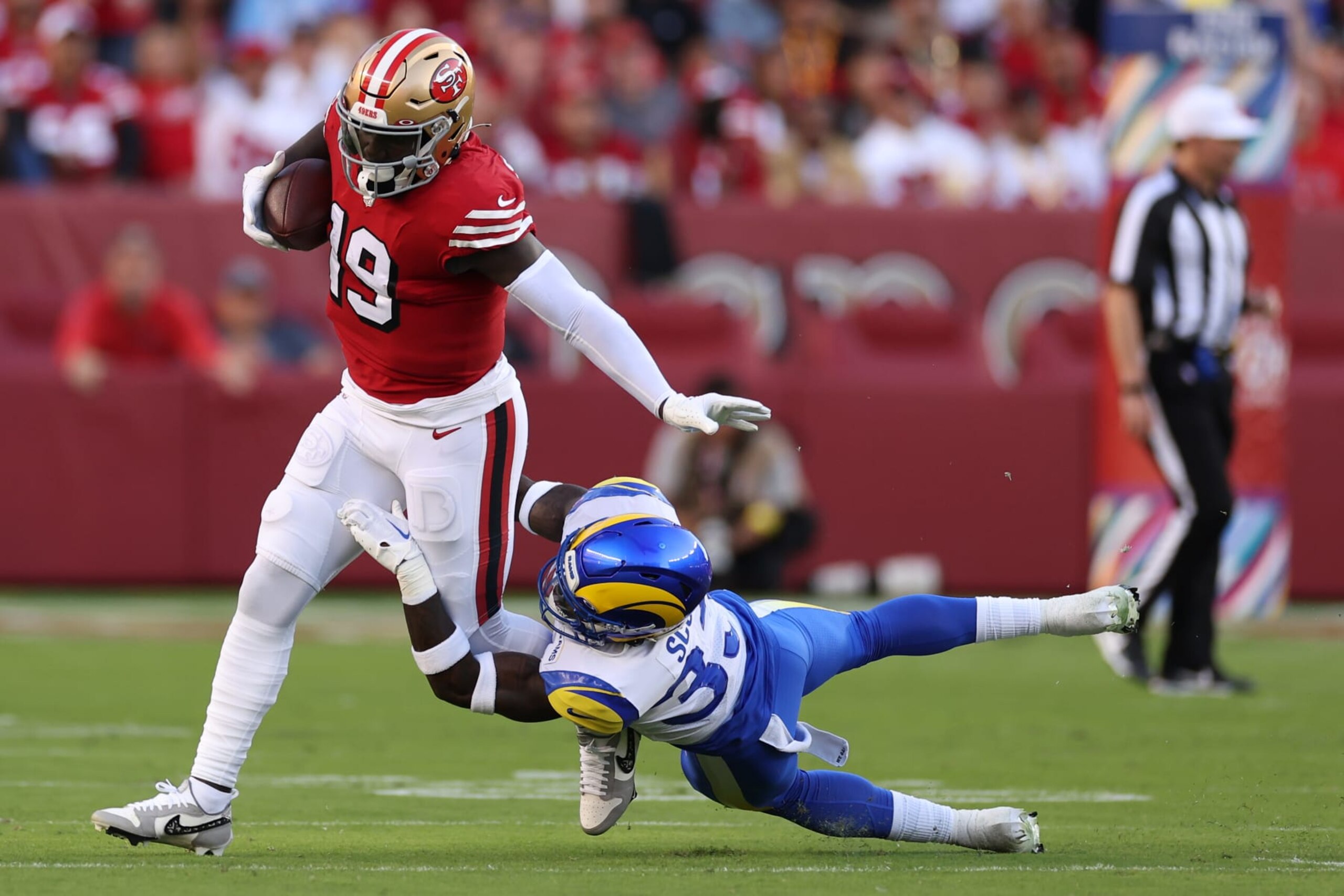 SANTA CLARA, CALIFORNIA - OCTOBER 03: Wide receiver Deebo Samuel #19 of the San Francisco 49ers is tackled by safety Nick Scott #33 of the Los Angeles Rams during the second quarter at Levi's Stadium on October 03, 2022 in Santa Clara, California. (Photo by Ezra Shaw/Getty Images)