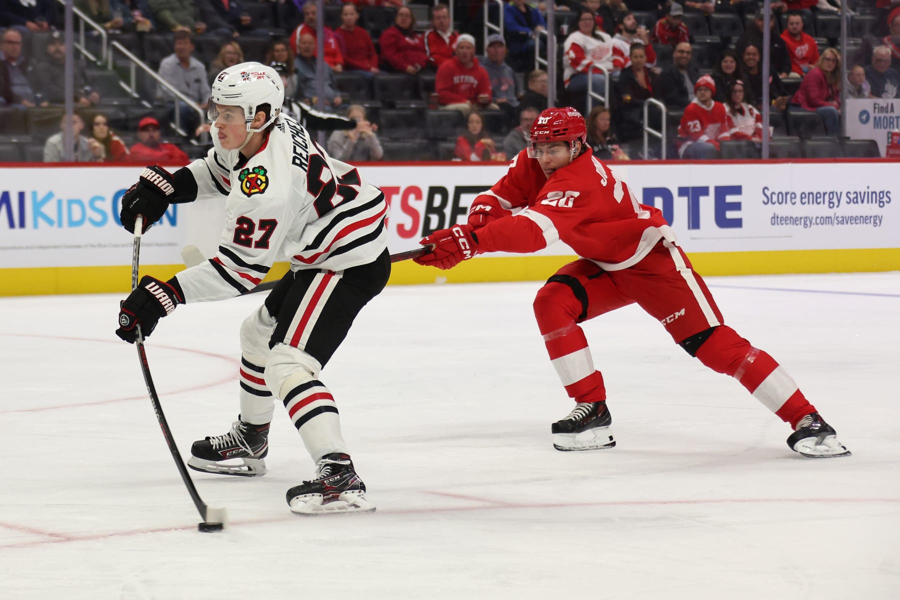 DETROIT, MICHIGAN - SEPTEMBER 28: Lukas Reichel #27 of the Chicago Blackhawks gets a shot off in the first period in front of Albert Johansson #20 of the Detroit Red Wings at Little Caesars Arena on September 28, 2022 in Detroit, Michigan. (Photo by Gregory Shamus/Getty Images)